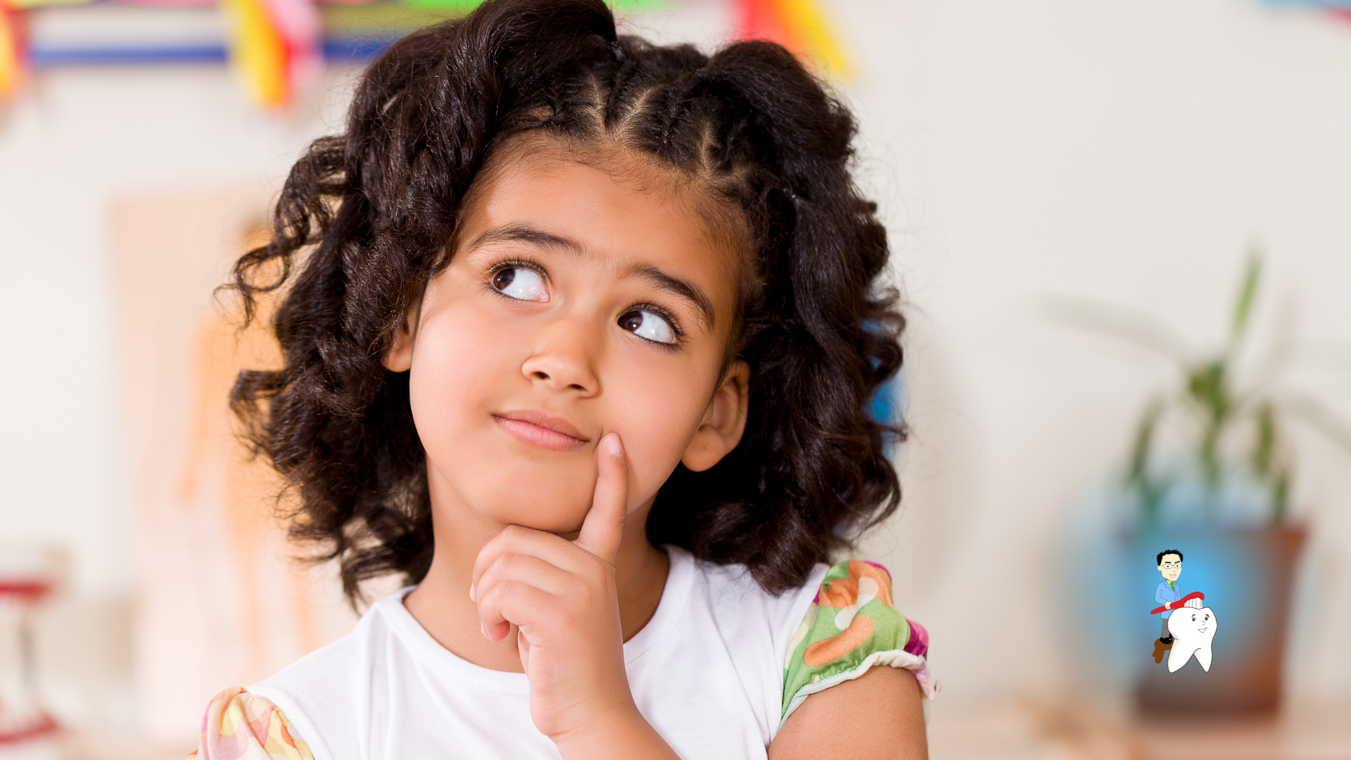 Girl with curly hair, chin on finger, looking upward thoughtfully. Blurred background.