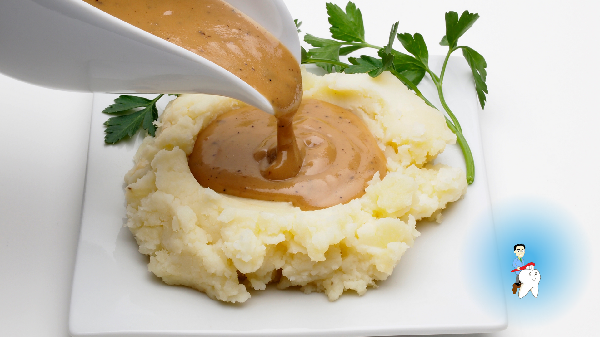 Gravy is being poured over mashed potatoes on a white plate.