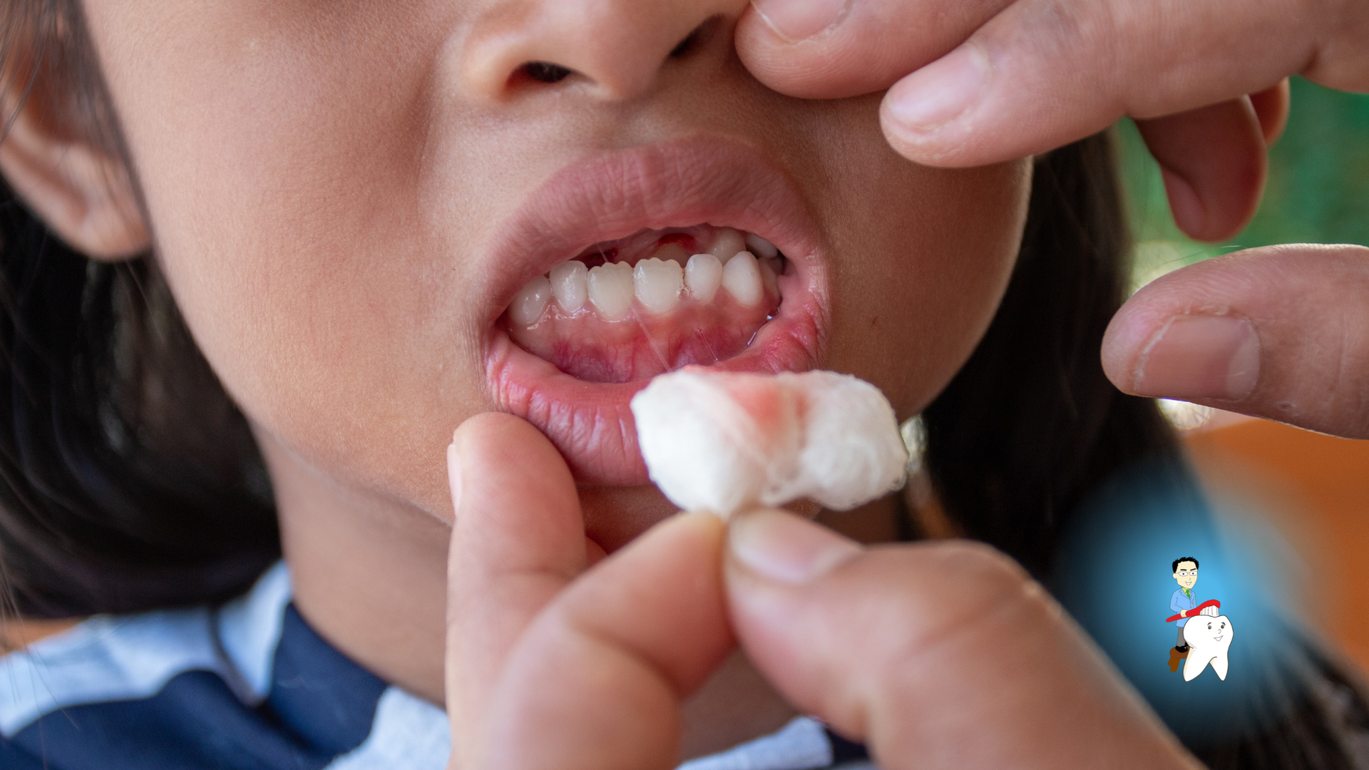 A person is holding a piece of cotton in a child 's mouth.