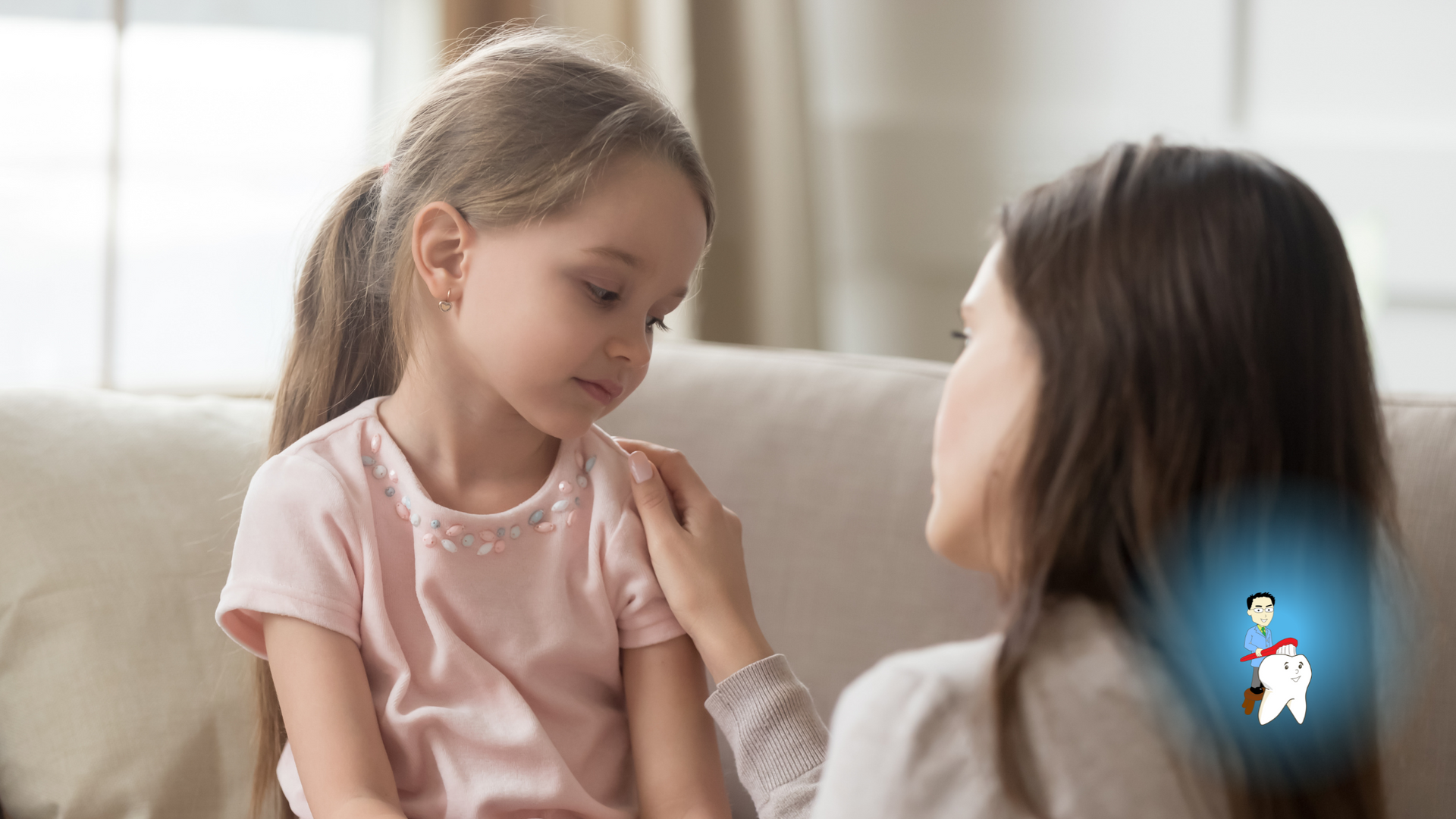 A woman is comforting a little girl who is sitting on a couch.