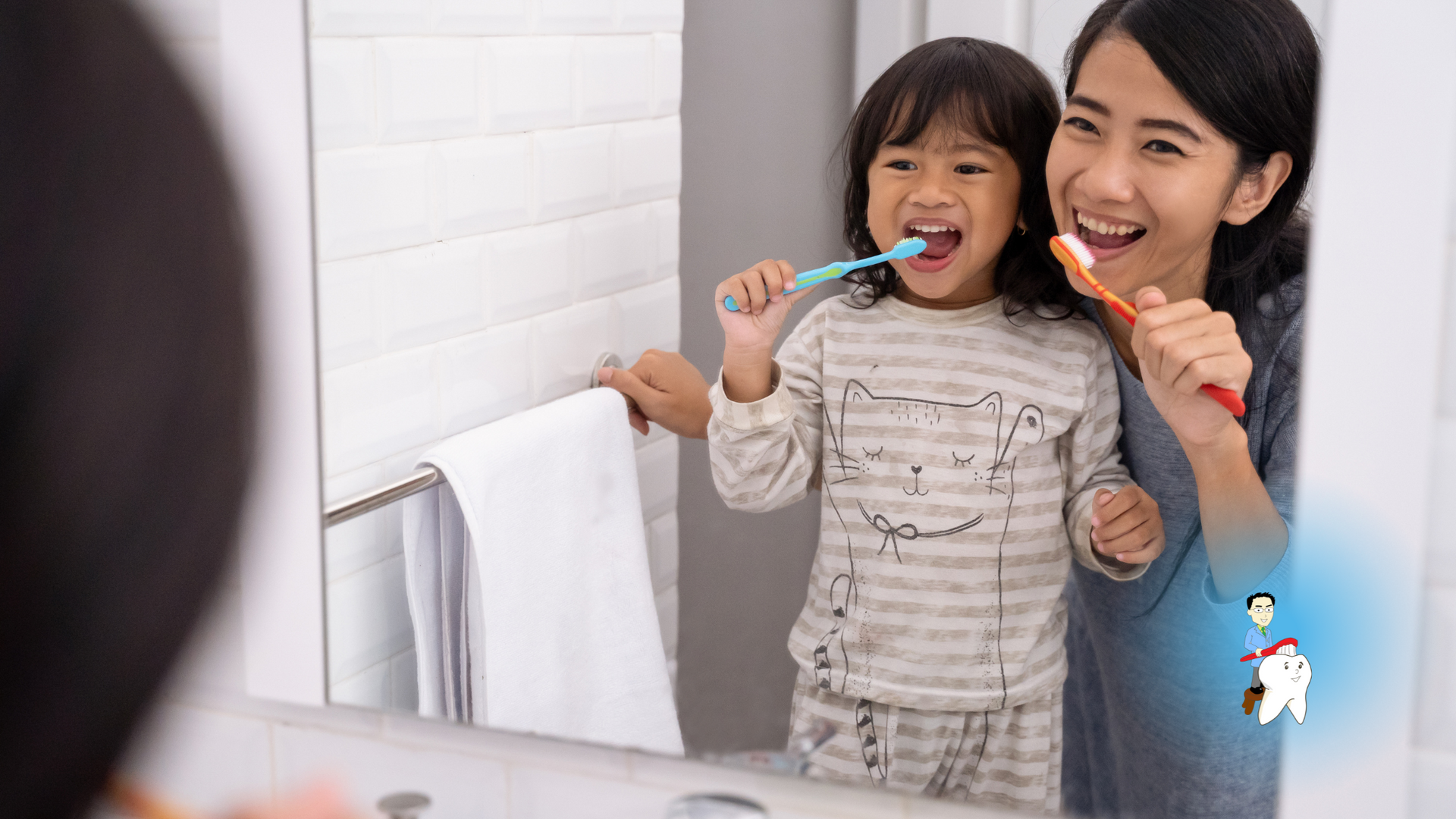 A woman and a child are brushing their teeth in front of a bathroom mirror.