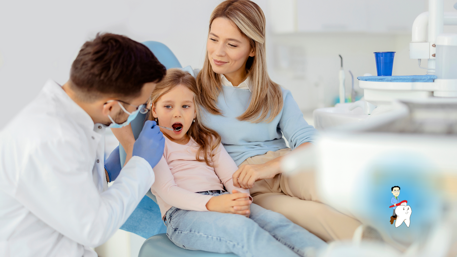 A little girl is sitting in a dental chair with her mother while a dentist examines her teeth.