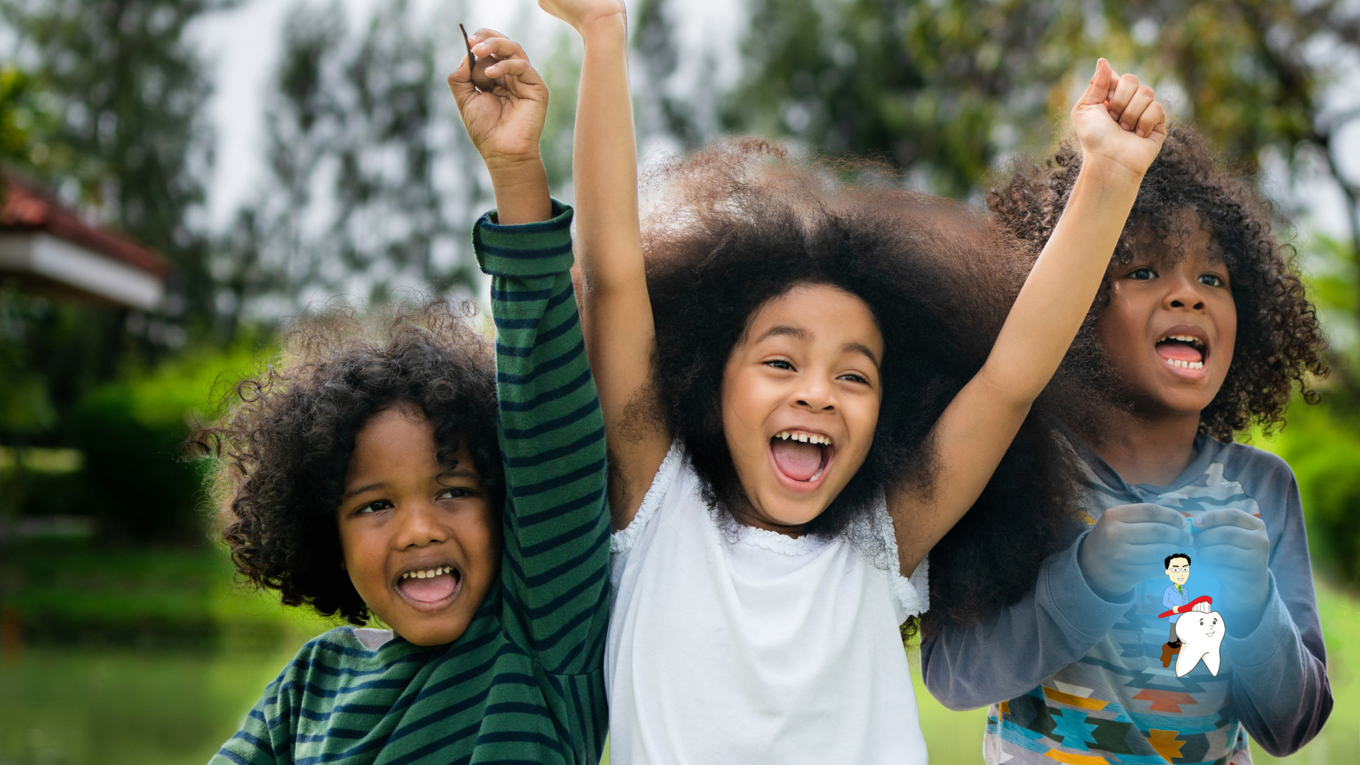 Three children are standing next to each other with their arms in the air.