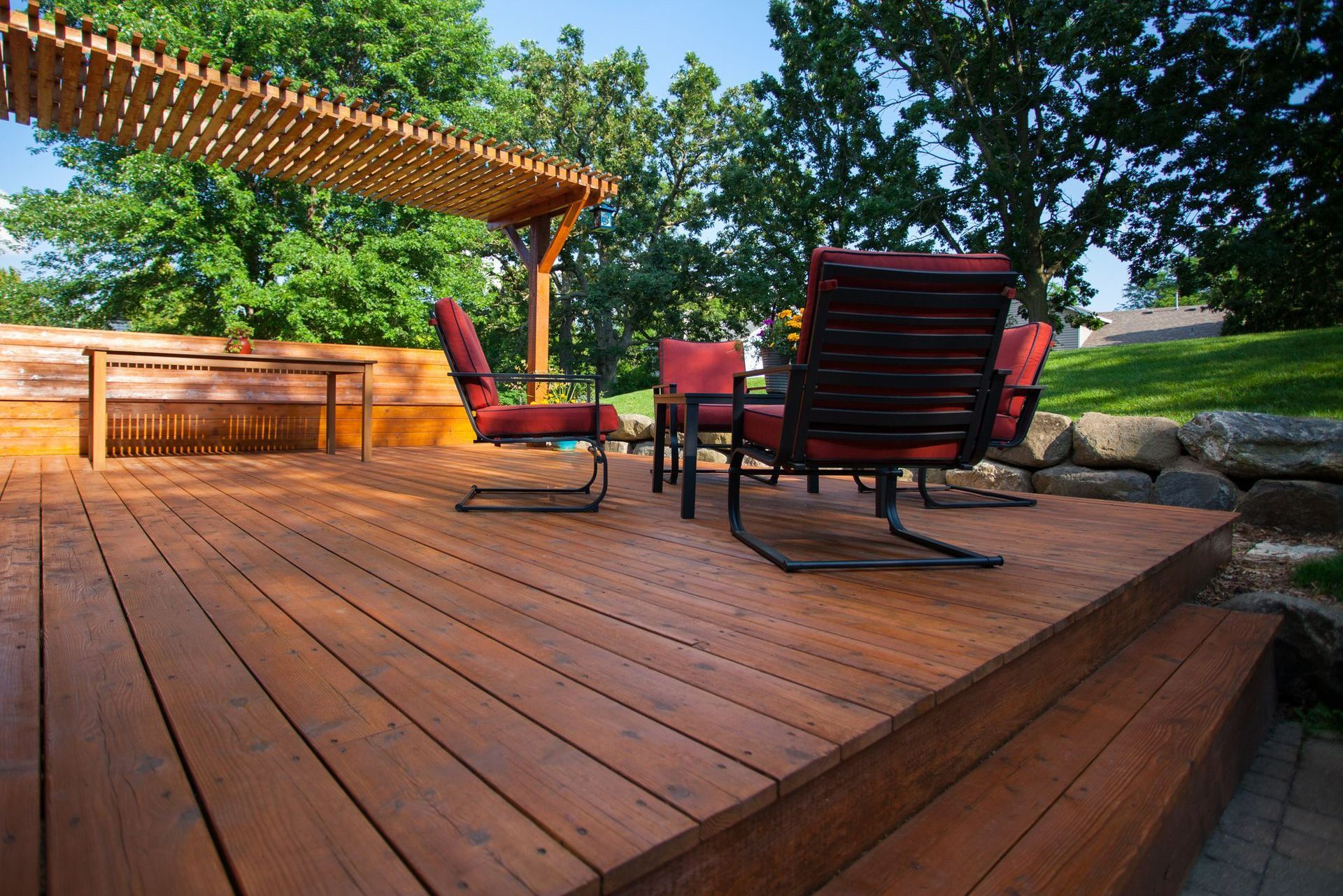 A Wooden Deck With A Pergola And Chairs — Huron, SD — Shaddai Construction