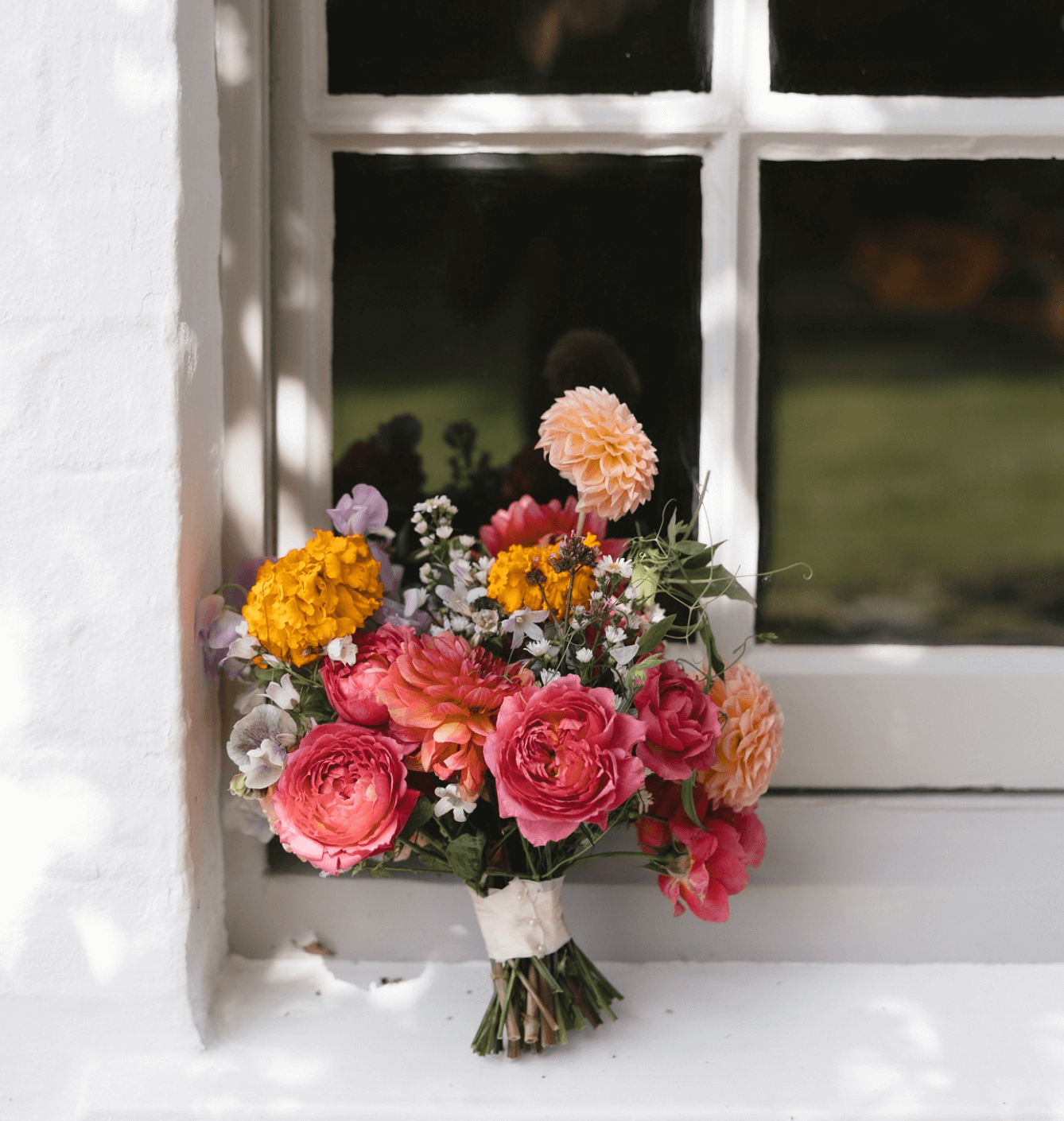 A bouquet of flowers is sitting on a window sill