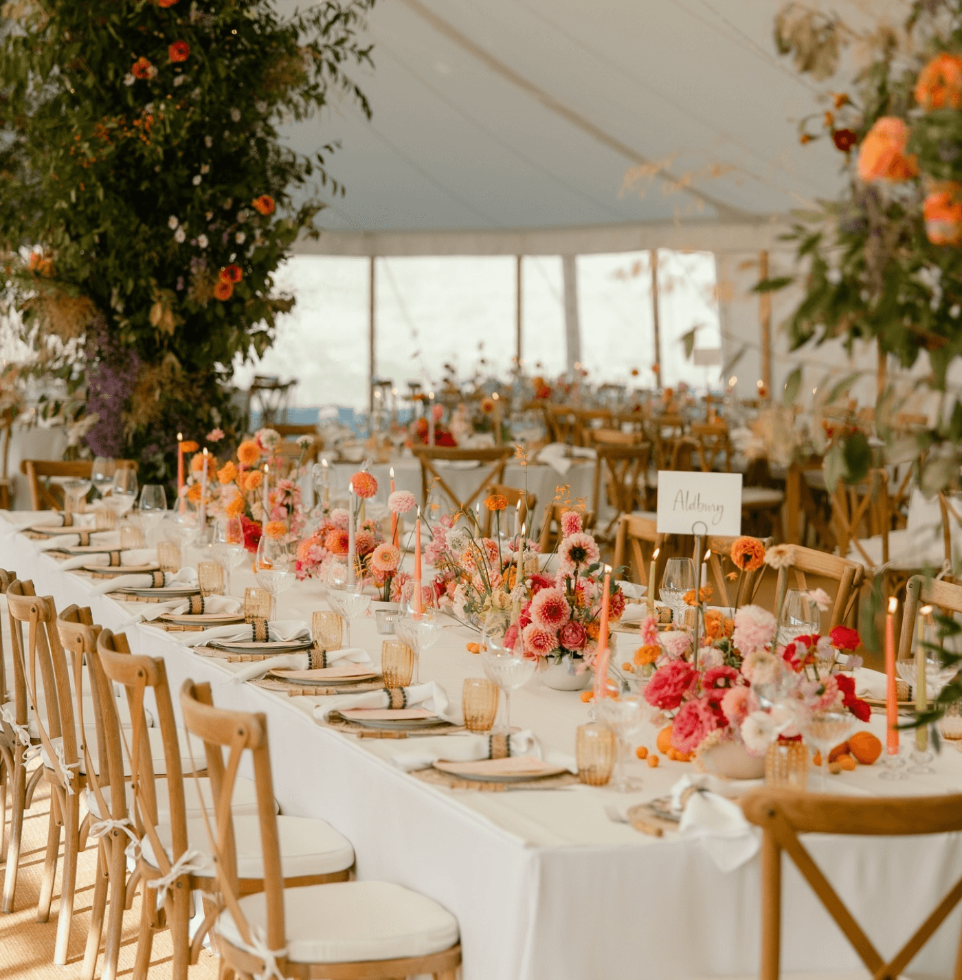 A long table with flowers on it is set up for a wedding reception.