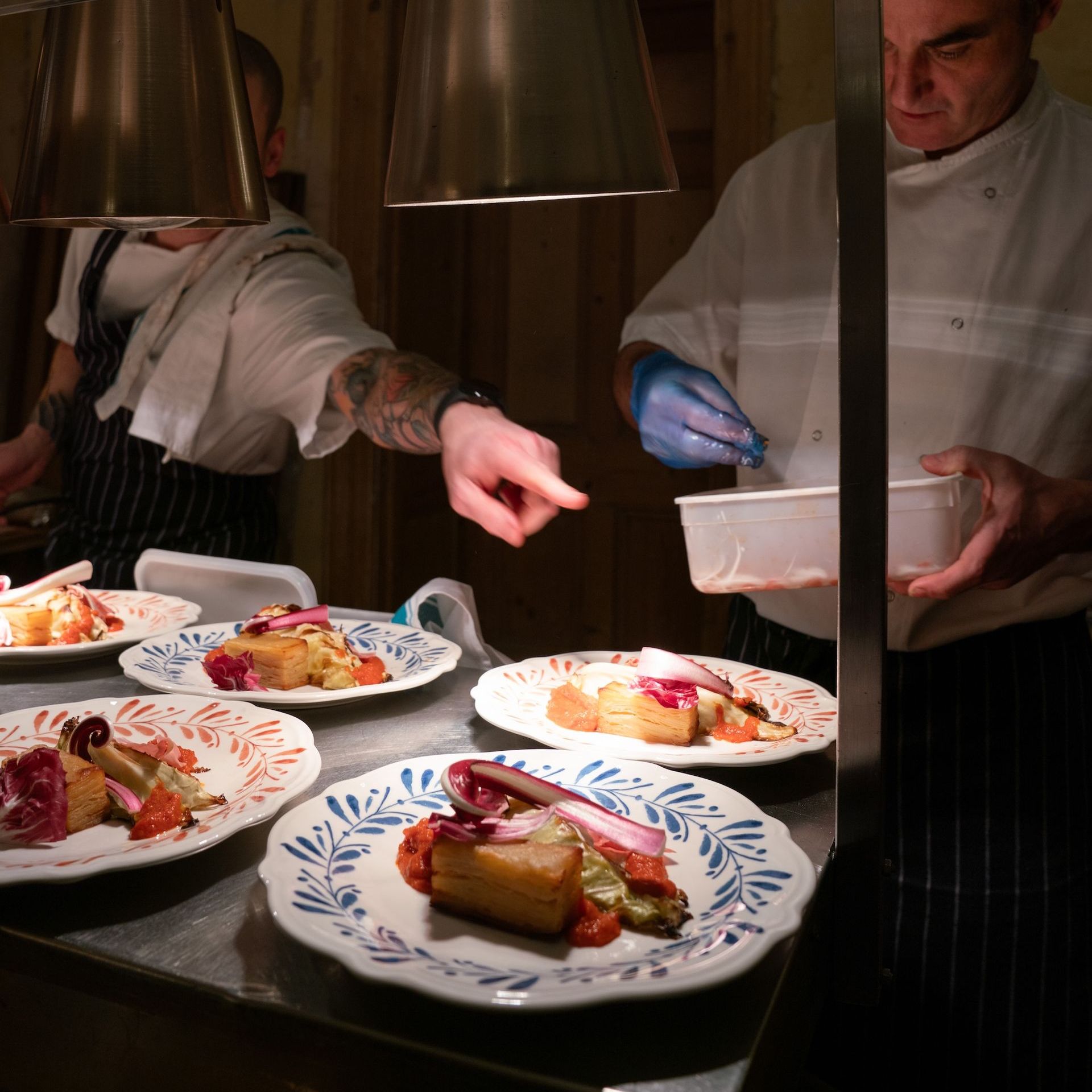 Chef plating up seasonal dishes for dinner party