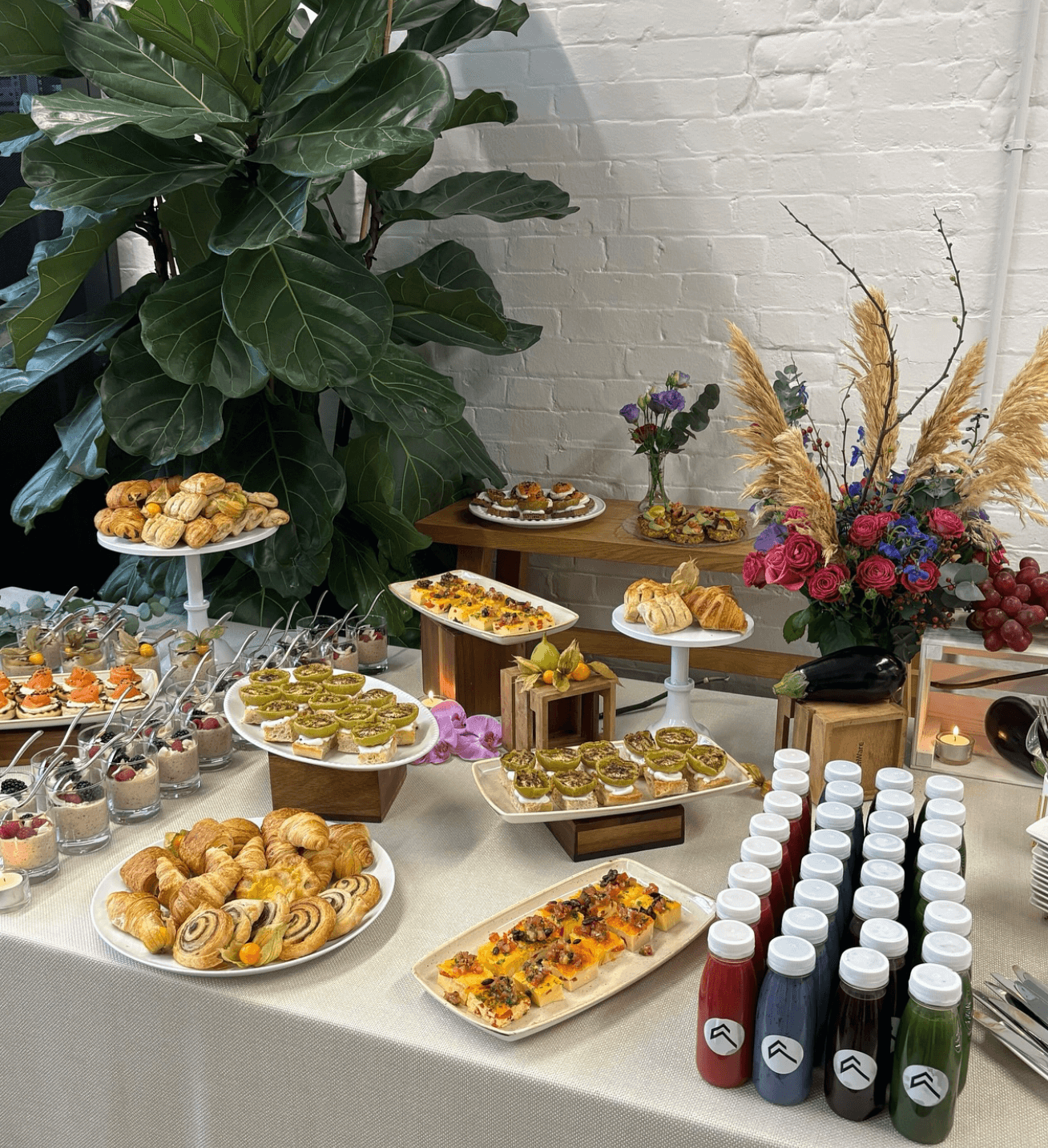 A table topped with plates of food and bottles of juice.