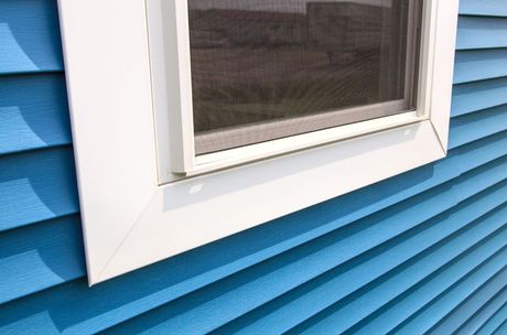 Picture of a new replaced vinyl white window with blue siding.