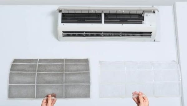 A person is cleaning the filter of an air conditioner.