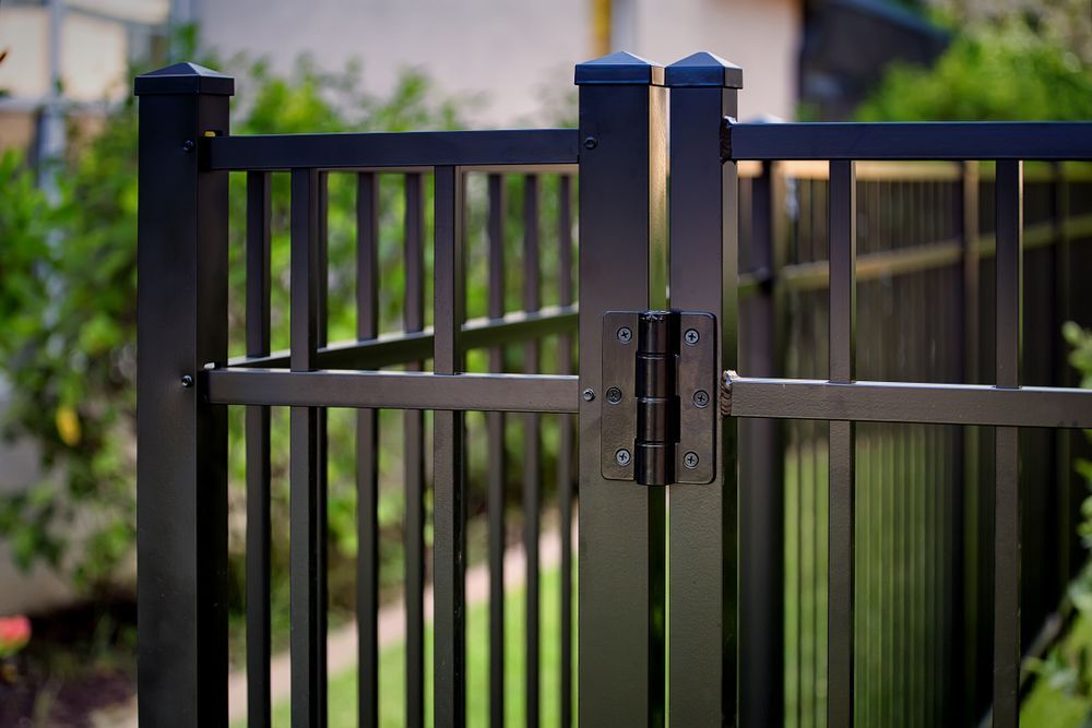 A Close Up of a Black Metal Fence With a Gate — Brendan's Landscaping and Fencing In Bundaberg, QLD
