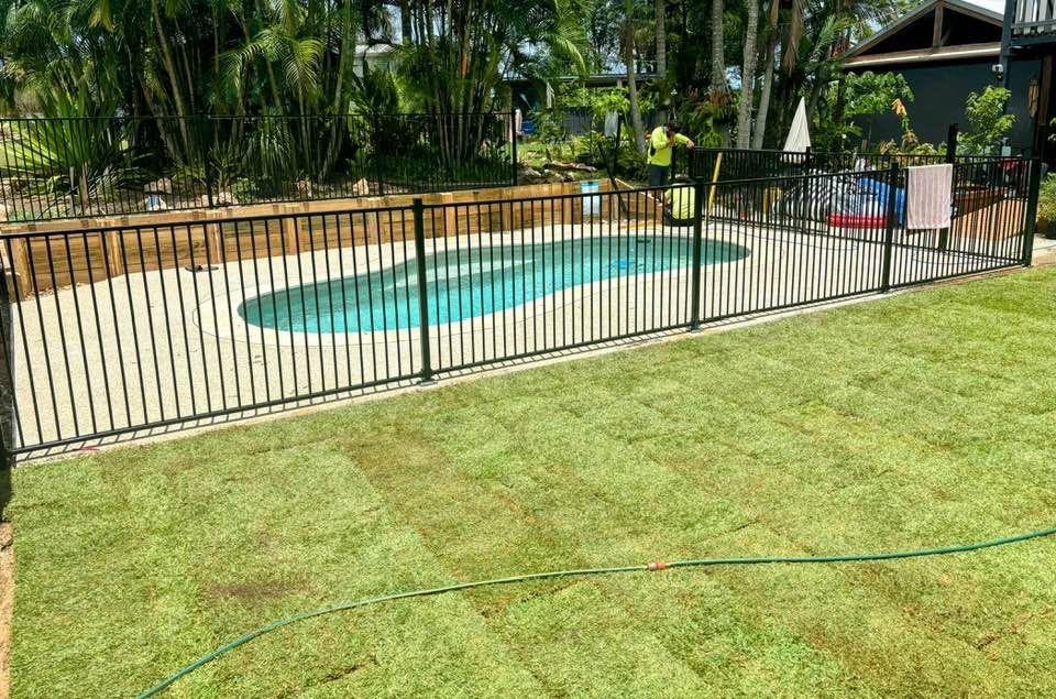 Black Fenced Pool Surrounded By Green Lawn