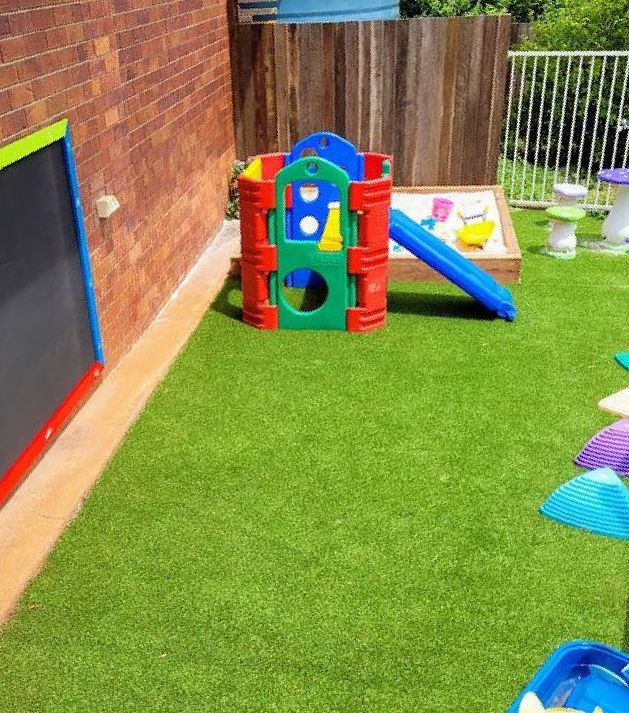A Roll of Artificial Grass is Sitting on Top of a Lush Green Field — Brendan's Landscaping and Fencing In Bundaberg, QLD