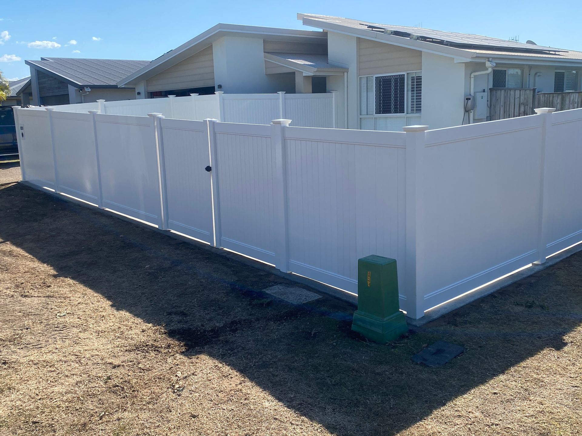 A Concrete Fence is Sitting on Top of a Dirt Field — Brendan's Landscaping and Fencing In Bundaberg, QLD
