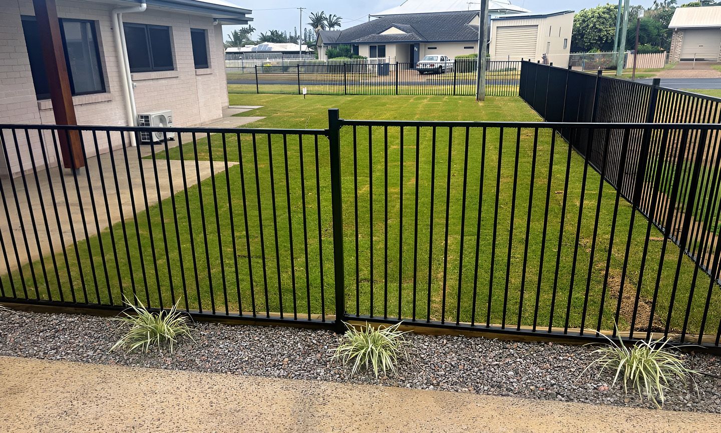 Black Metal Fence Around A Grassy Yard