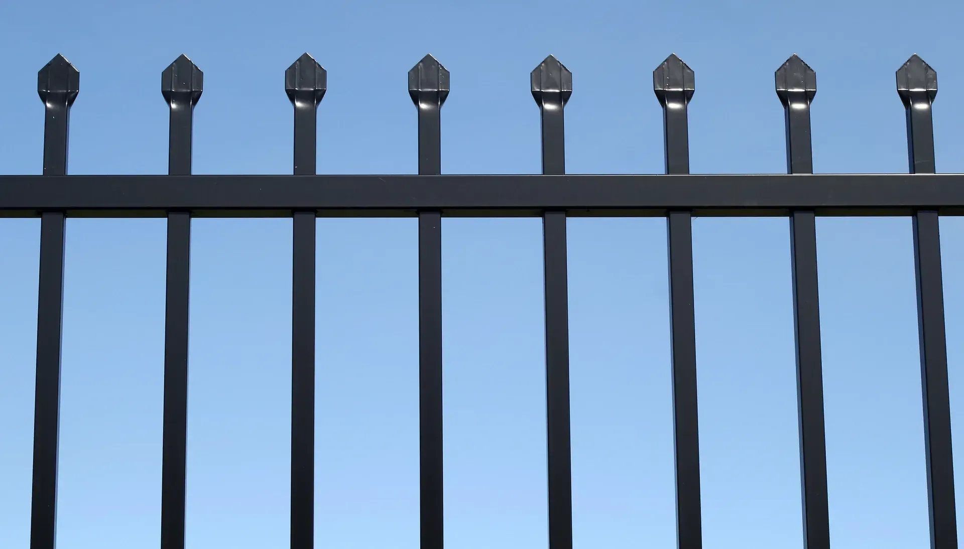 A Fence Made of Bricks and Metal is Surrounded by Brick Pillars — Brendan's Landscaping and Fencing In Bundaberg, QLD