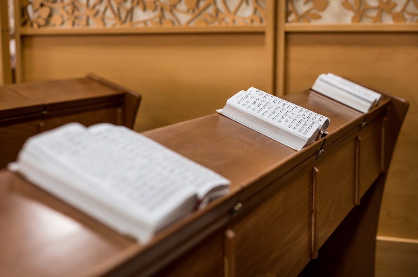 שני ספרים יושבים על שולחן עץ באולם בית המשפט.