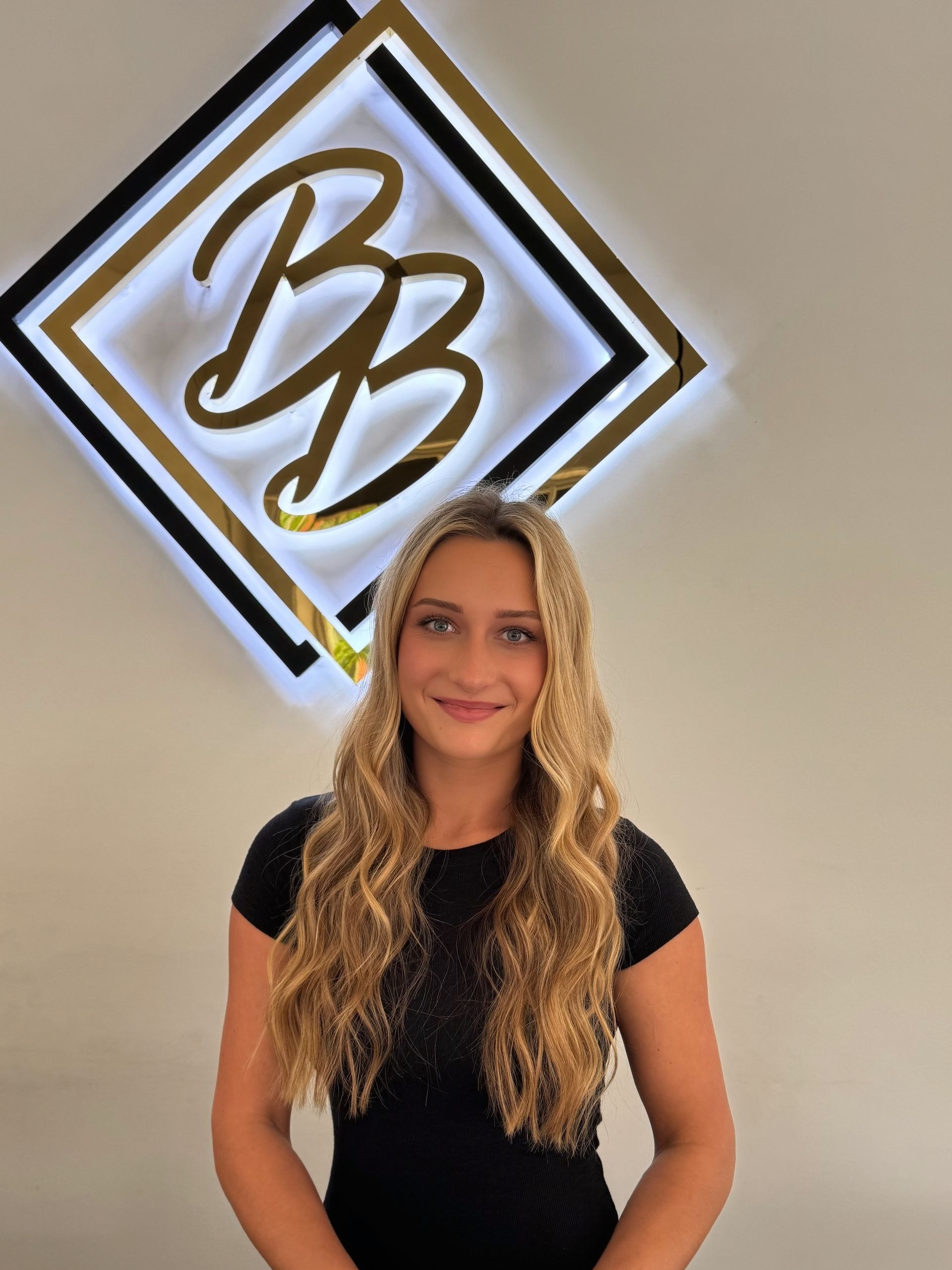 A woman is standing in front of a sign that says BB