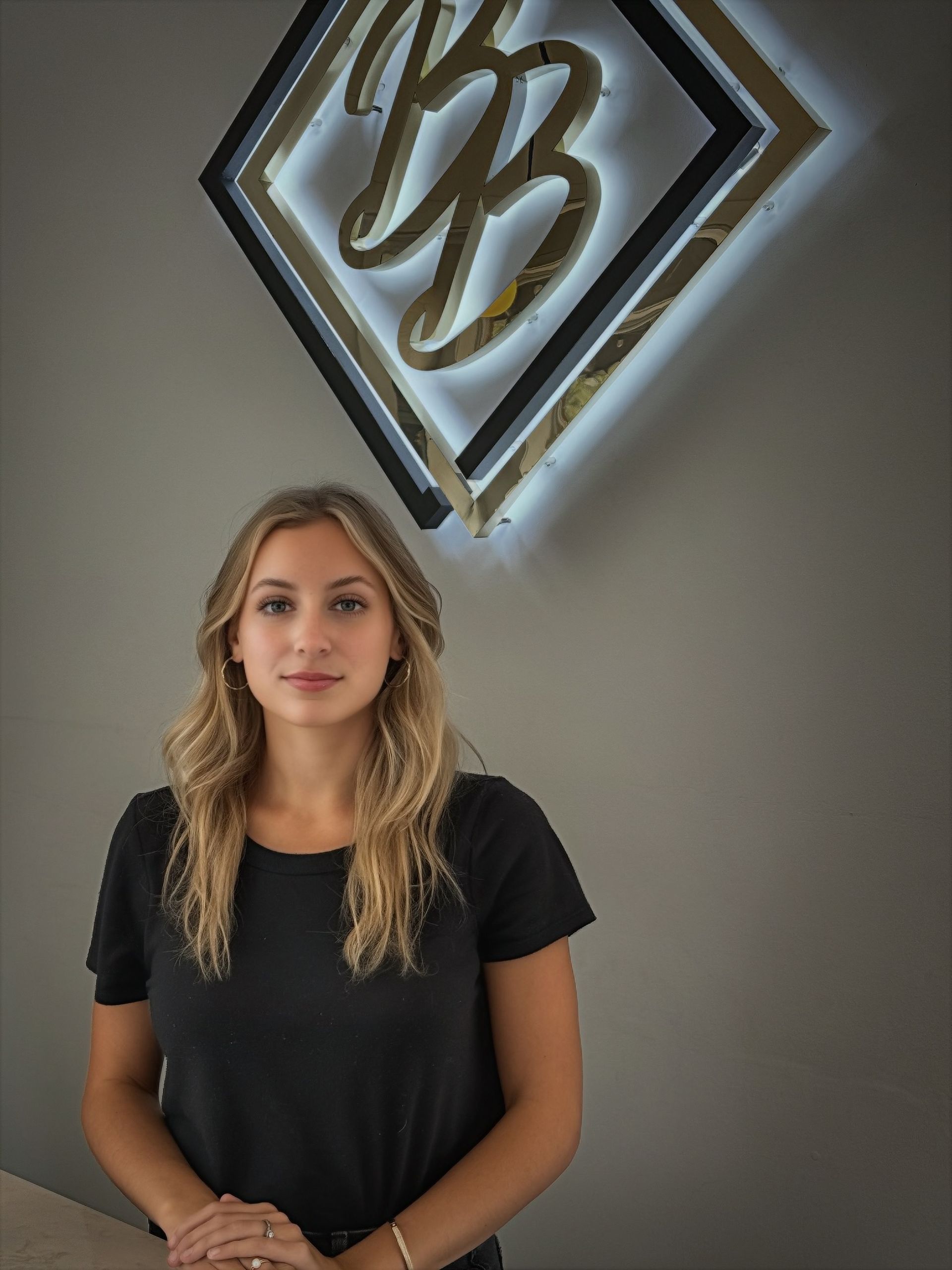 A woman is standing in front of a sign that says BB