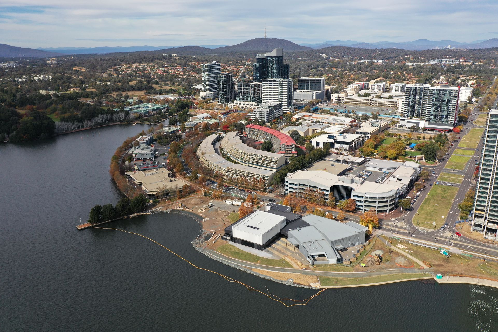 Aerial view of Canberra cityscape with buildings, lake, and mountains in the background — Canberra Windscreens In Woden, ACT