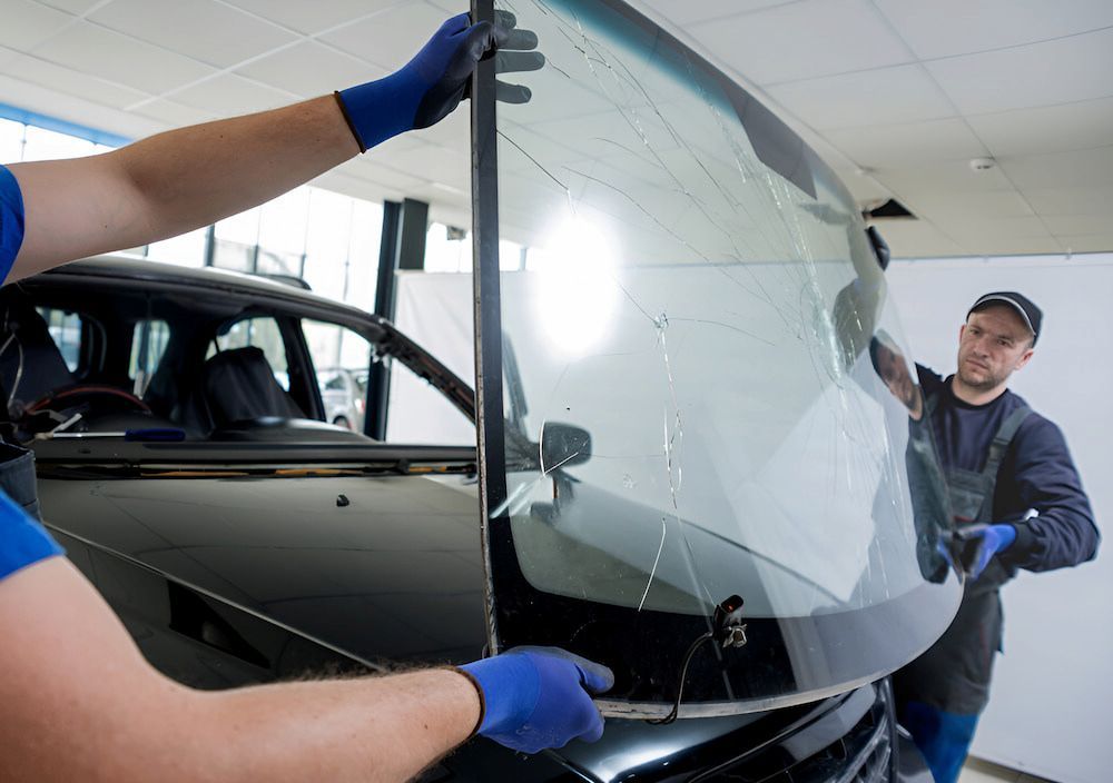 Two Men Are Installing A Windshield On A Car — Canberra Windscreens In Conder, ACT