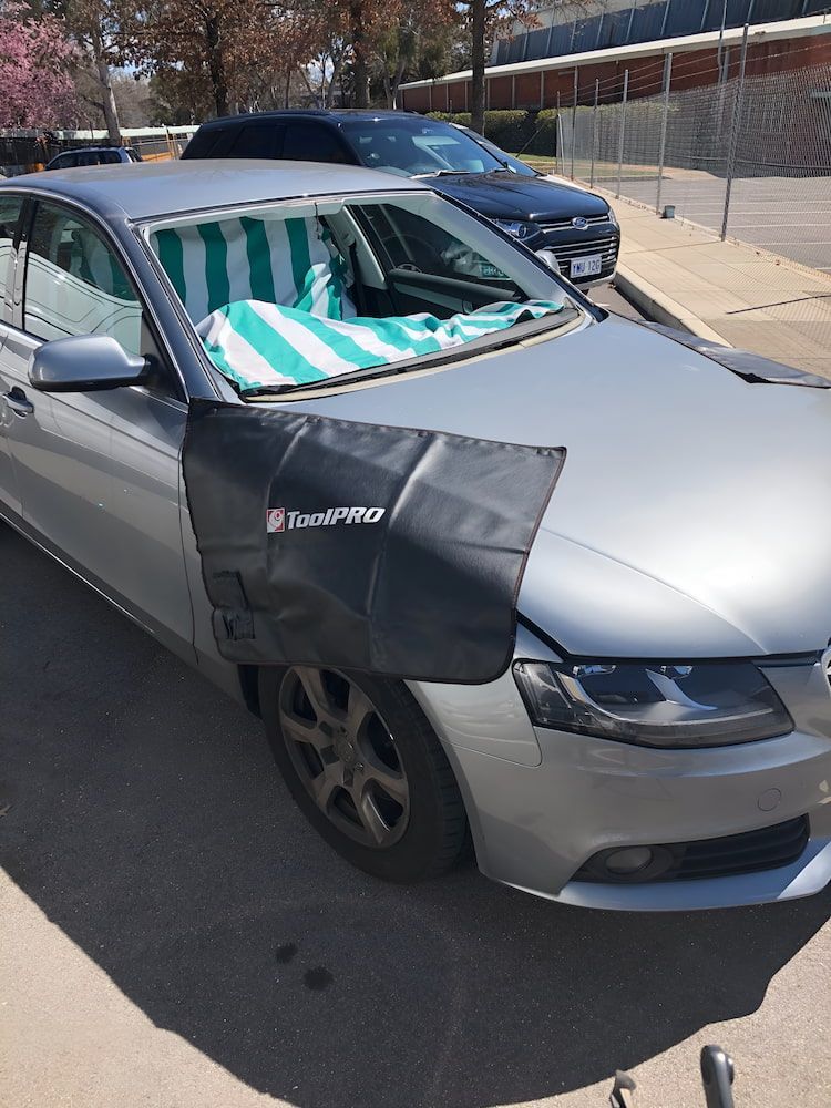 A Silver Car With A Towel On The Windshield Is Parked In A Parking Lot — Canberra Windscreens In Conder, ACT