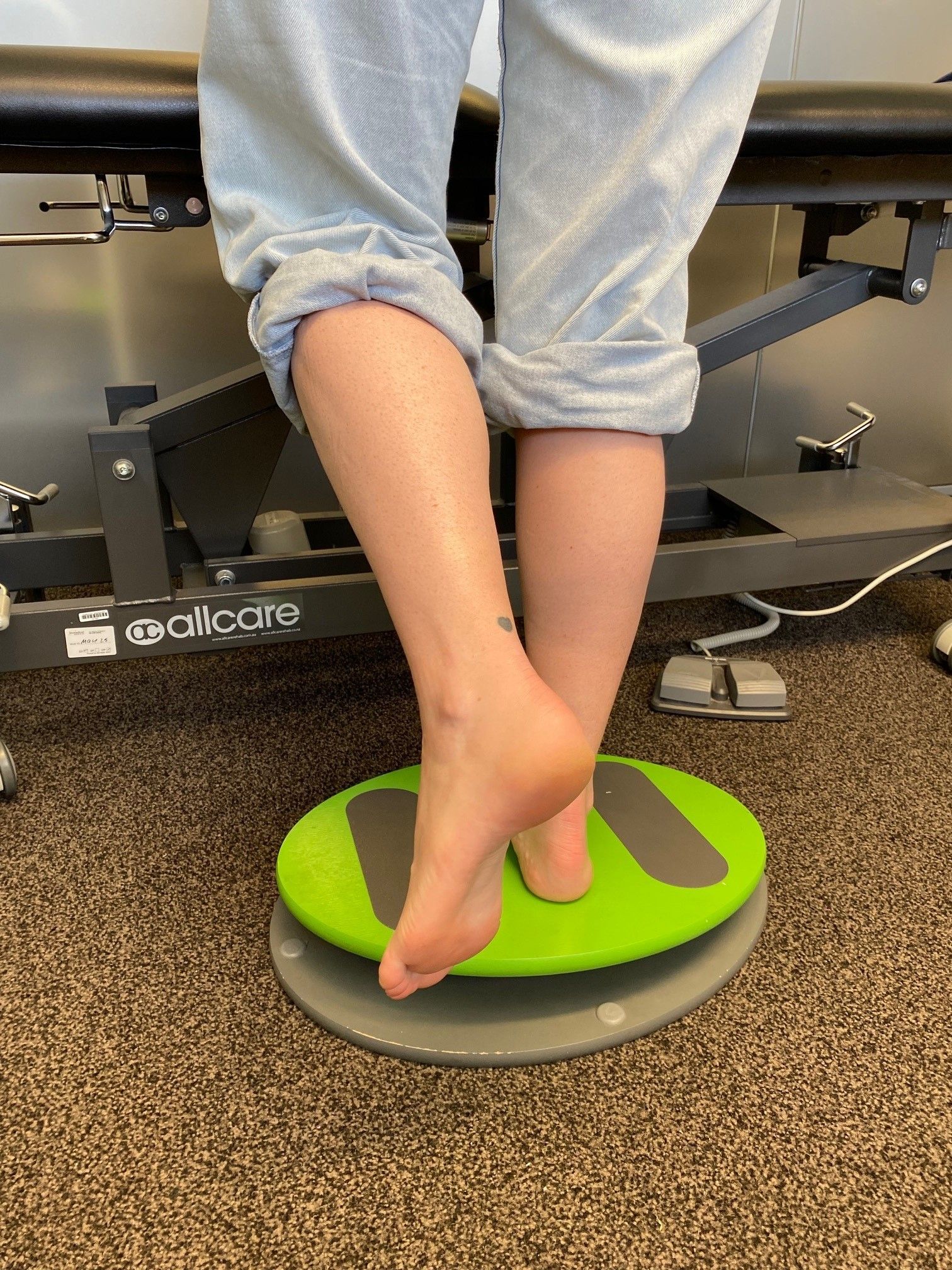 A person is laying on a table with a towel on their feet.