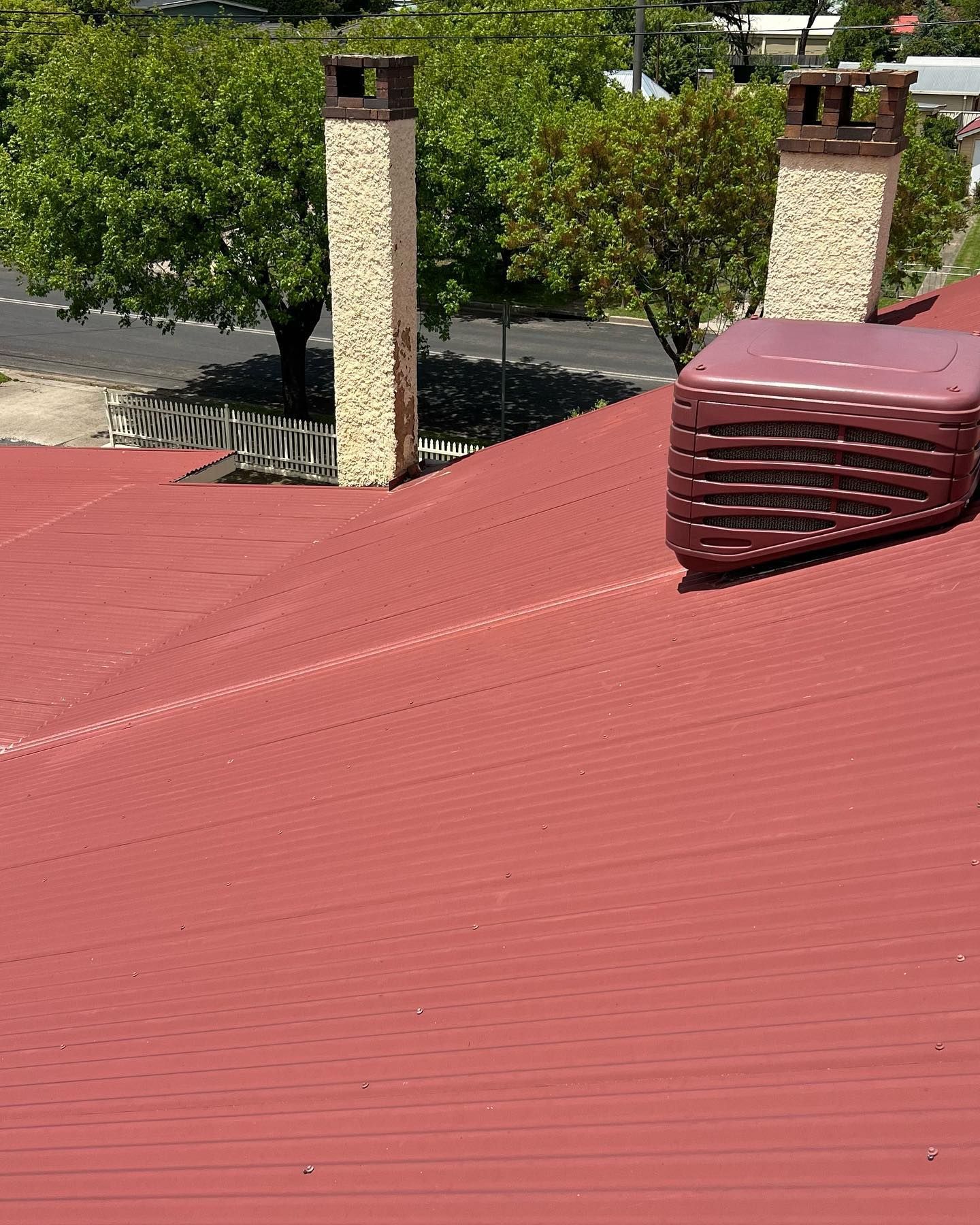 Red Corrugated Metal Roof With Two Chimneys — Ace Metal Roofing in Maclean, NSW