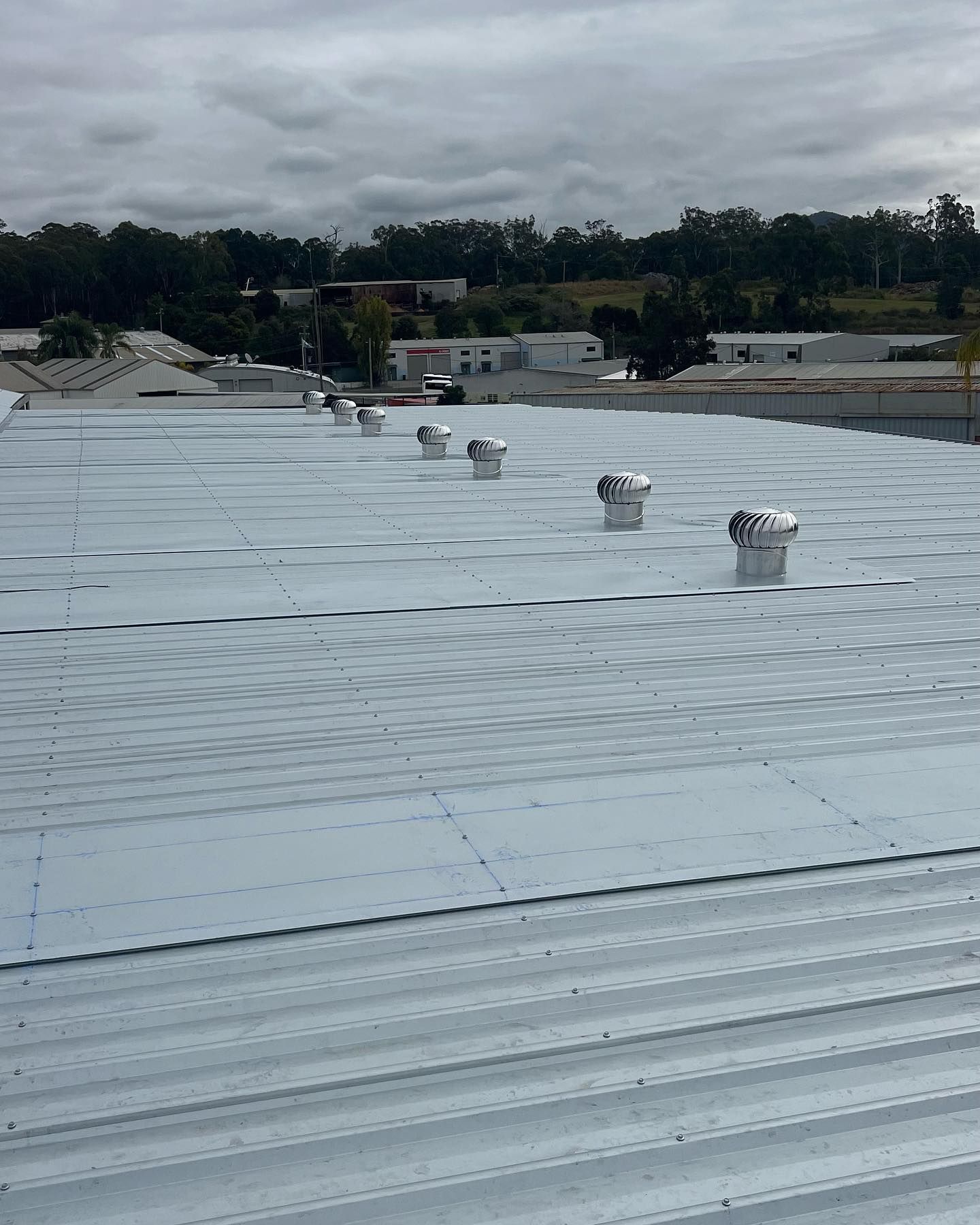 A Flat Metal Roof With Several Ventilation Units — Ace Metal Roofing in Waterview Heights, NSW