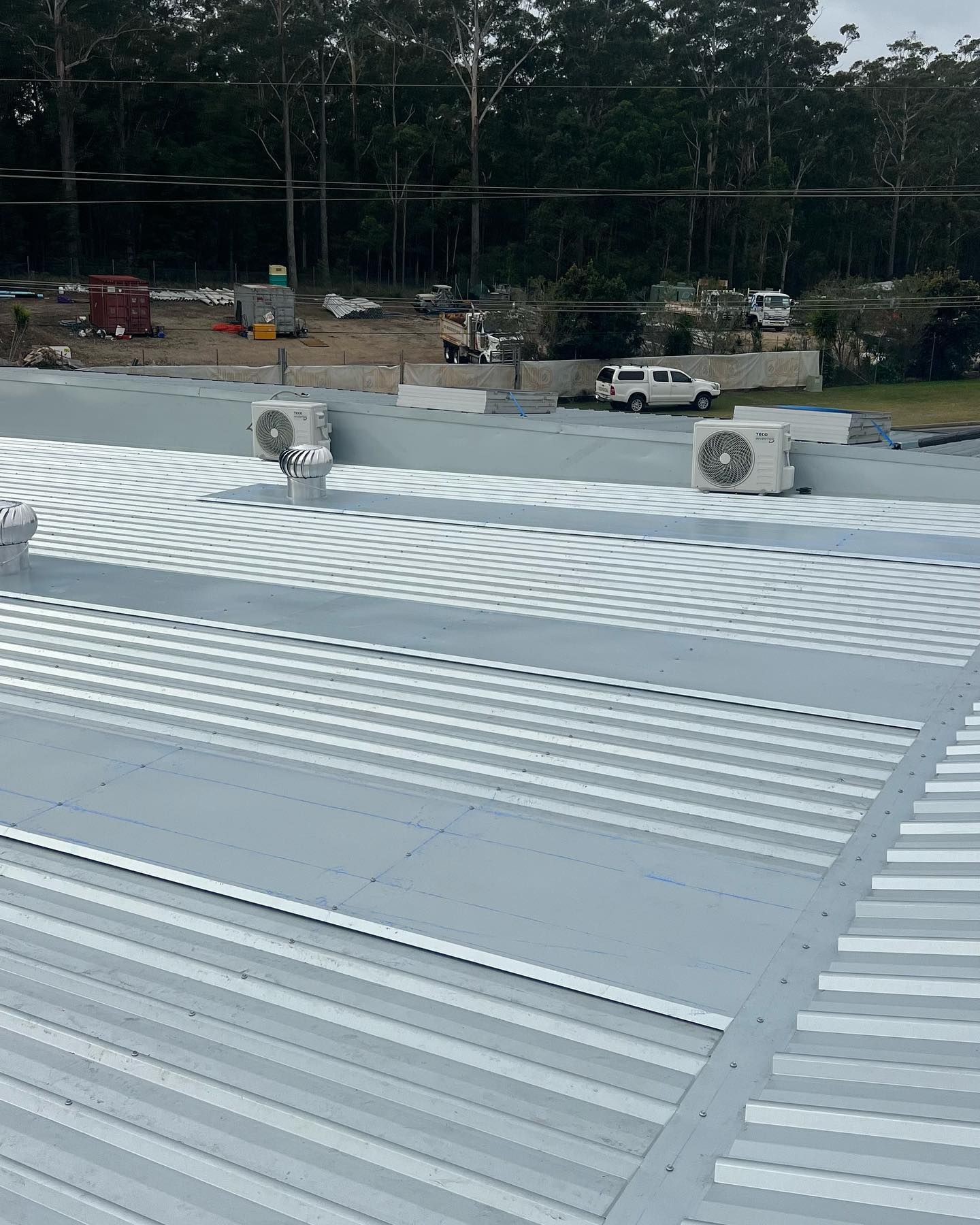 Metal Corrugated Roof With Gray Coating, Vents, and Air Conditioning Units — Ace Metal Roofing in Waterview Heights, NSW