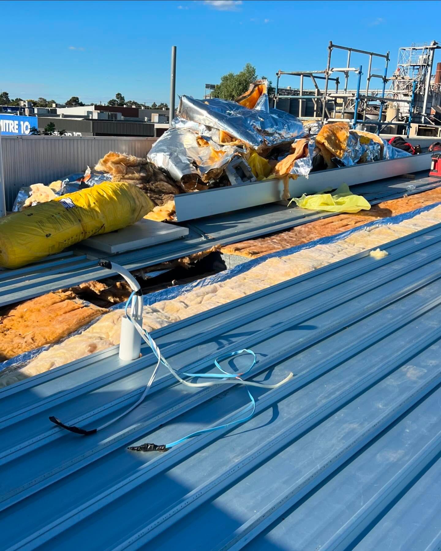 Construction Debris on a Corrugated Metal Roof Under a Bright Blue Sky — Ace Metal Roofing in Coffs Harbour, NSW
