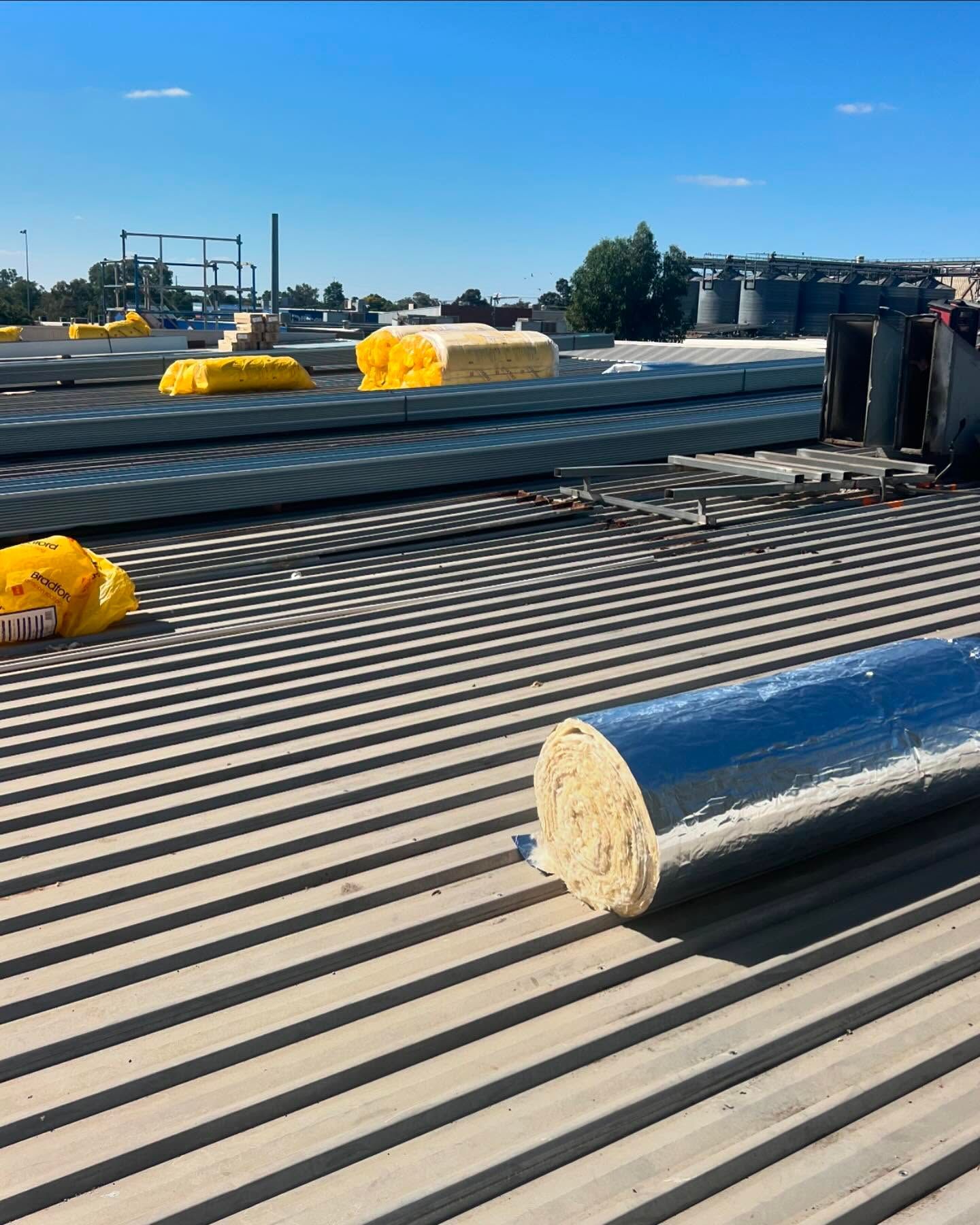 Roll of Insulation on a Corrugated Metal Roof — Ace Metal Roofing in Ballina, NSW