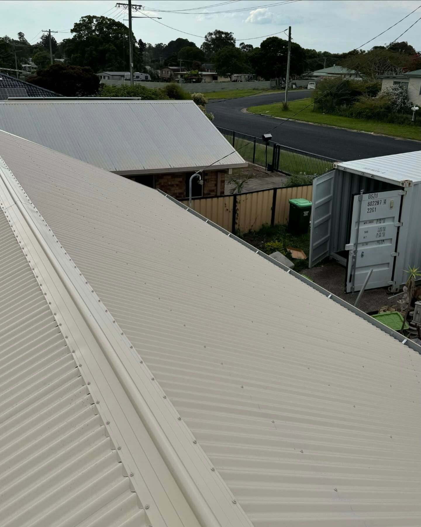 View of corrugated metal roof with surrounding buildings and street — Ace Metal Roofing in Iluka, NSW