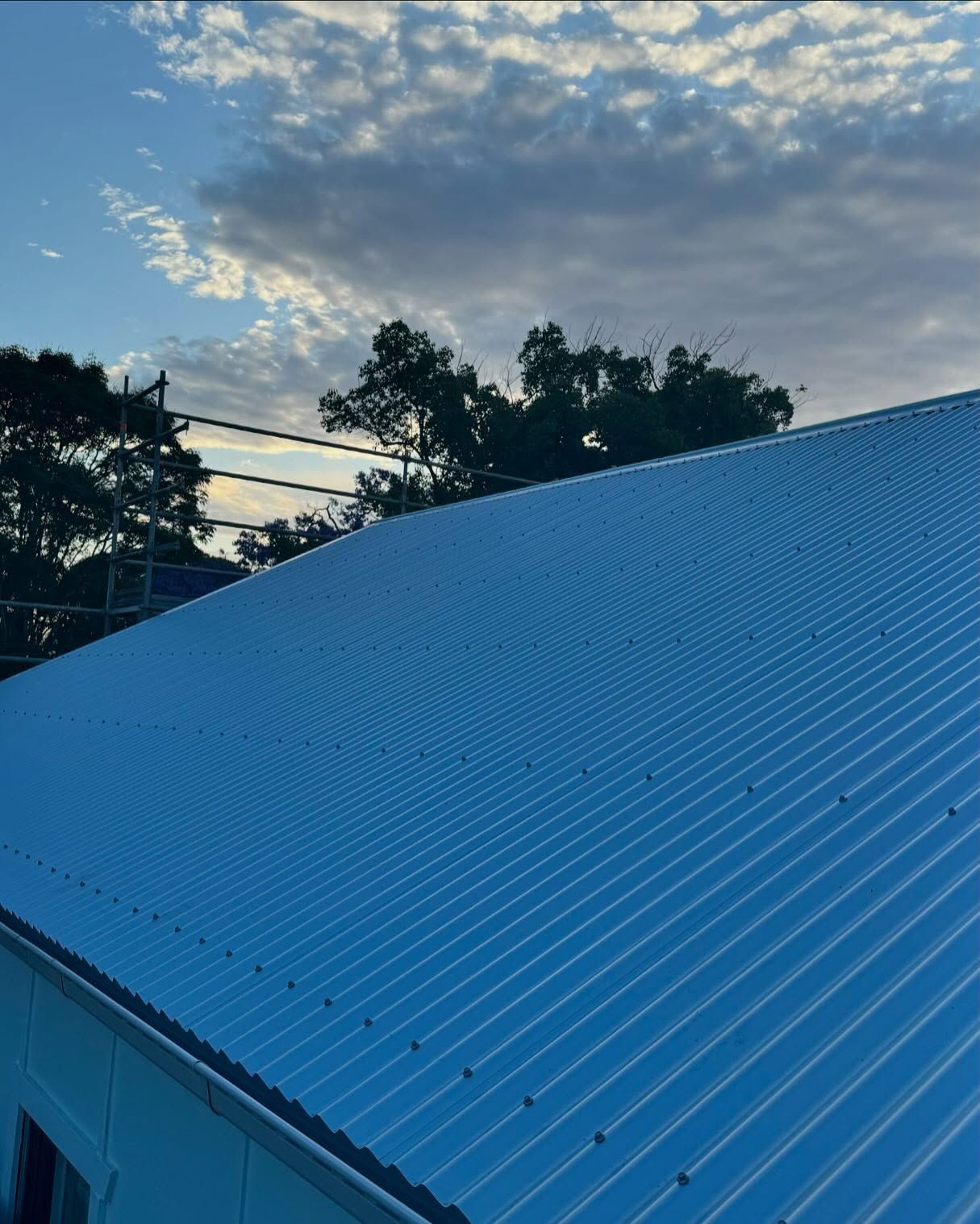 Corrugated Metal Roof Against a Cloudy Sky With Trees in the Background — Ace Metal Roofing in Waterview Heights, NSW
