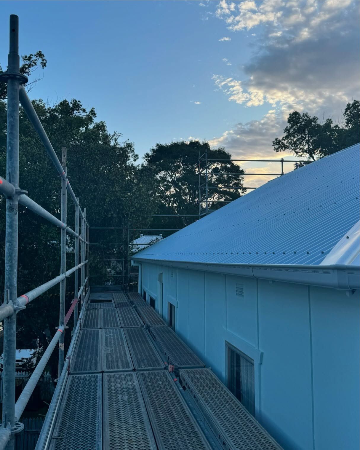 Scaffolding alongside a white building with a corrugated metal roof — Ace Metal Roofing in Waterview Heights, NSW