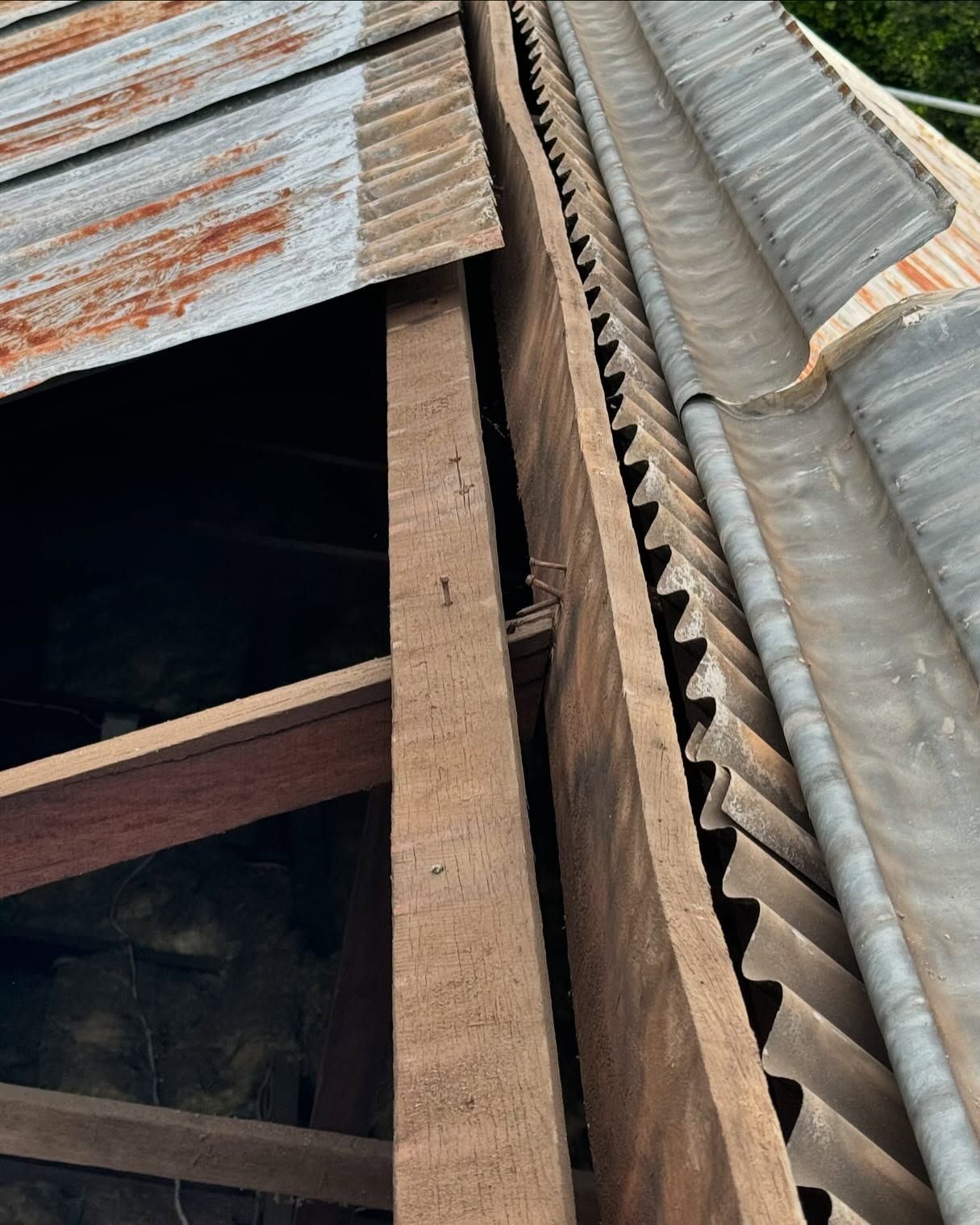 Close-up View of Weathered Corrugated Metal Roofing and Wooden Beams — Ace Metal Roofing in Waterview Heights, NSW