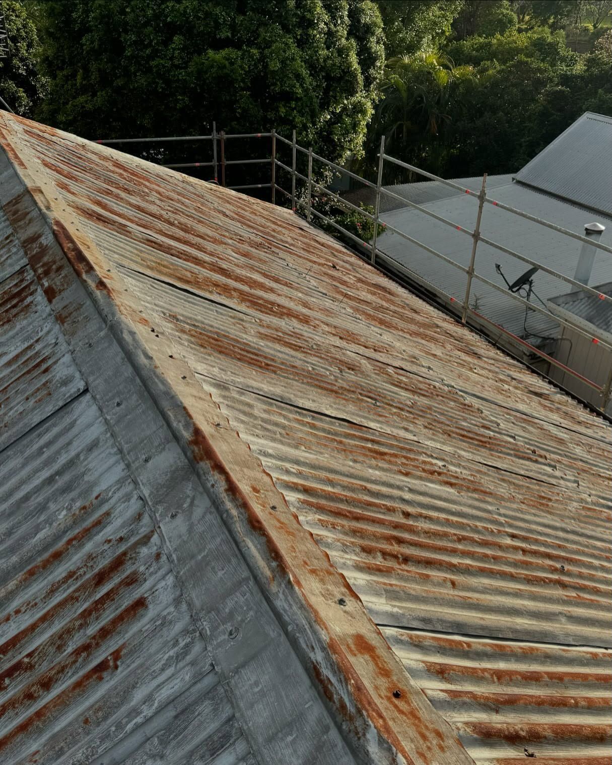 Rusty Corrugated Metal Roof. Scaffolding and Trees in the Background — Ace Metal Roofing in Waterview Heights, NSW