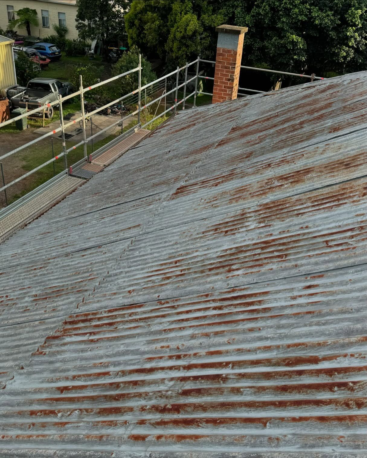 Corrugated Metal Roof With Rust Spots, Near a Brick Chimney and Scaffolding — Ace Metal Roofing in Waterview Heights, NSW