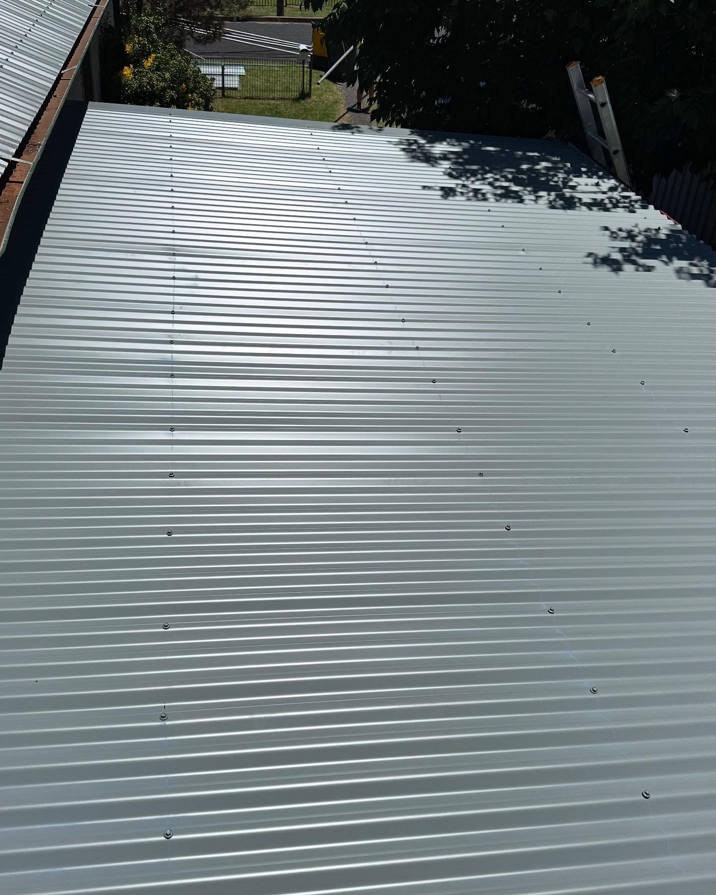 Gray Corrugated Metal Roof on a Building, With Sun Glinting Off It — Ace Metal Roofing in Iluka, NSW