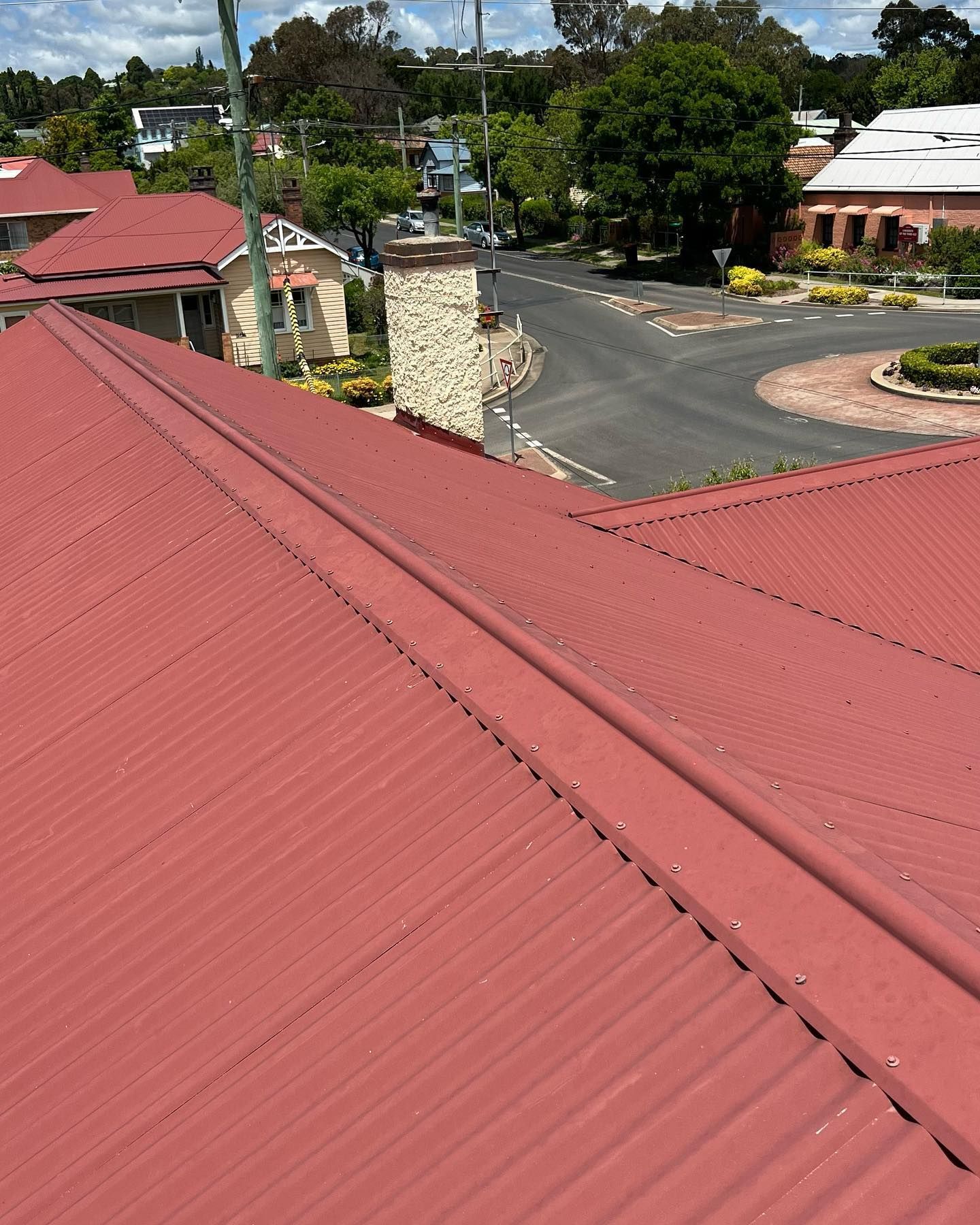 Red Corrugated Metal Roof of a Building With a Chimney — Ace Metal Roofing in Waterview Heights, NSW