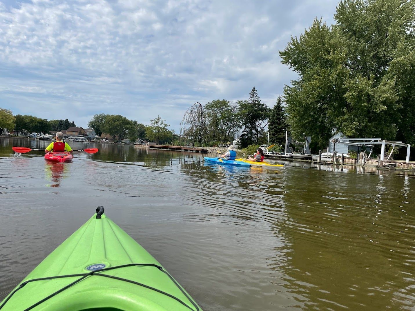 A group of people are paddling kayaks on a lake.