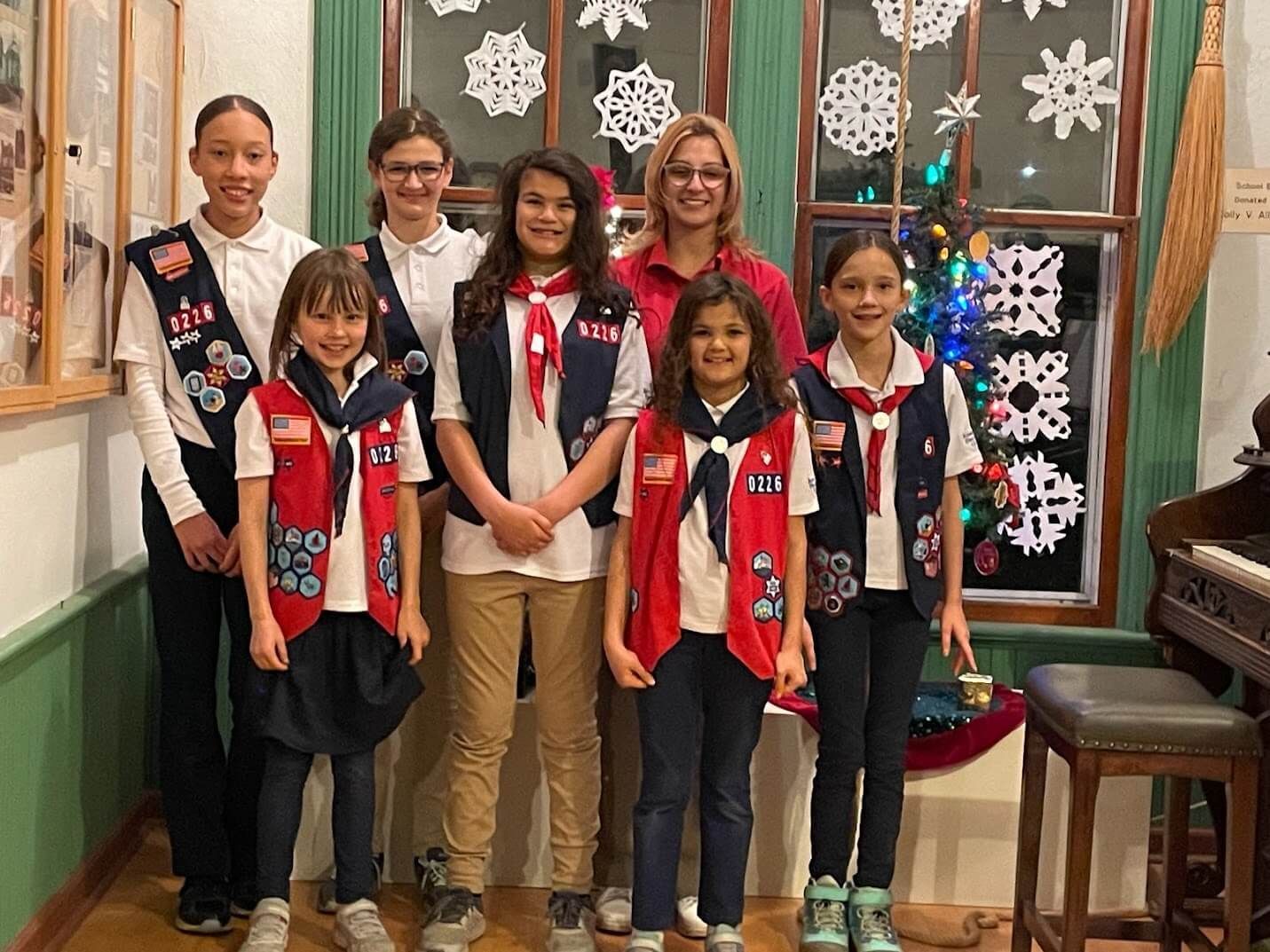 A group of girl scouts are posing for a picture in a room.