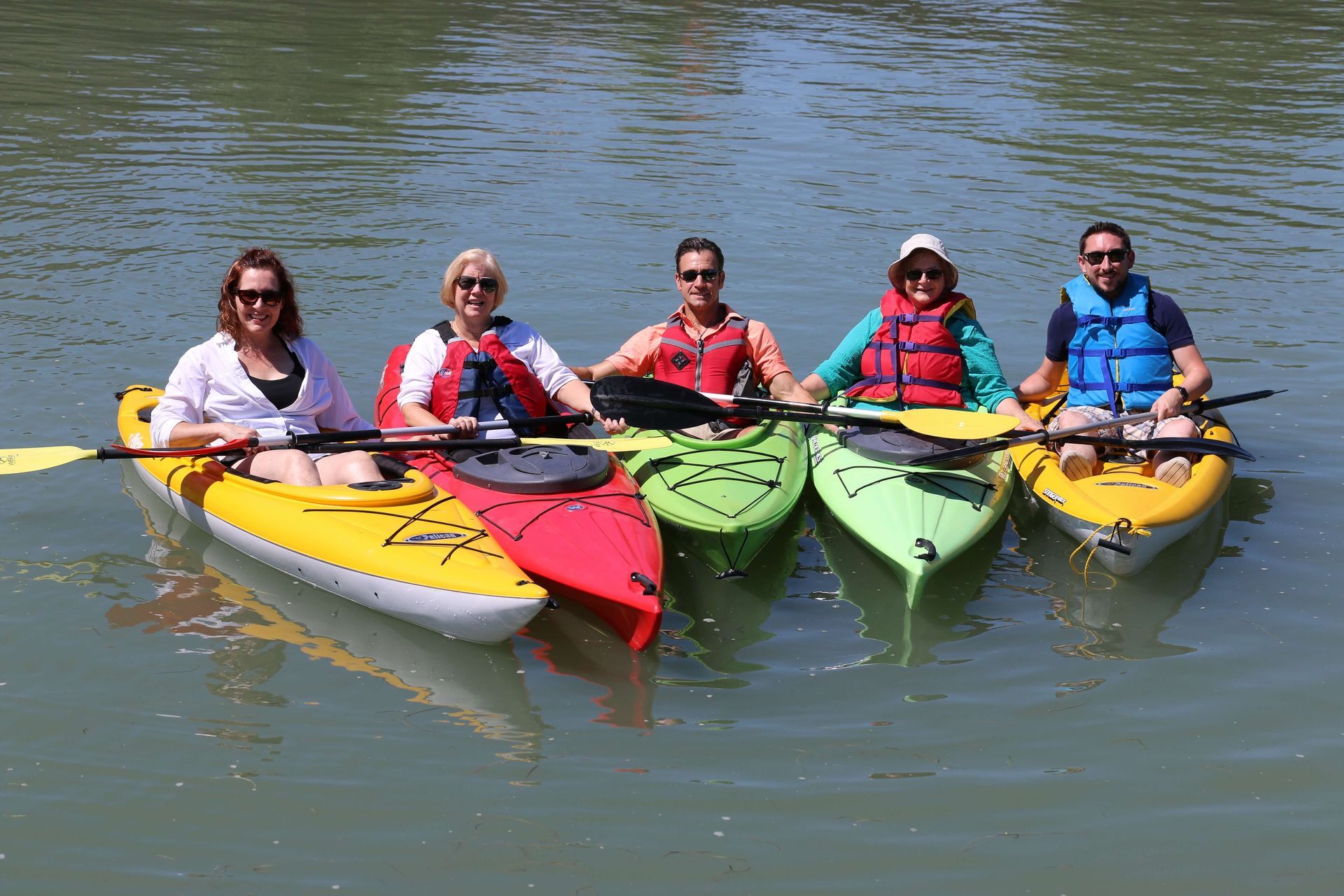 A group of people are sitting in kayaks in the water.