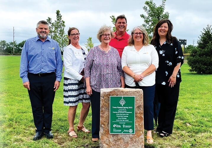 A group of people standing next to each other in a grassy field.