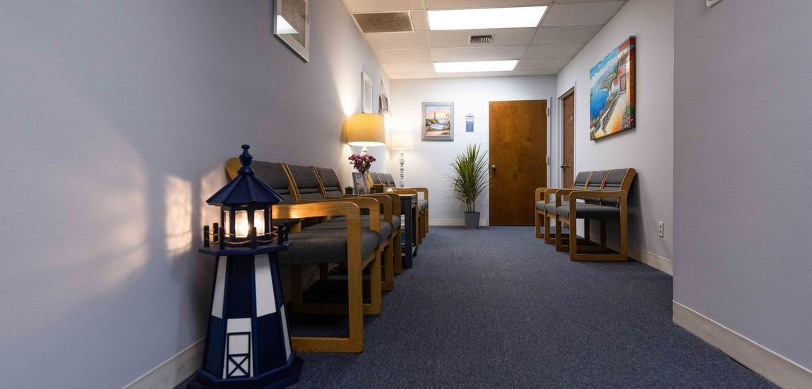 A hallway with chairs and a lighthouse on the side of it.