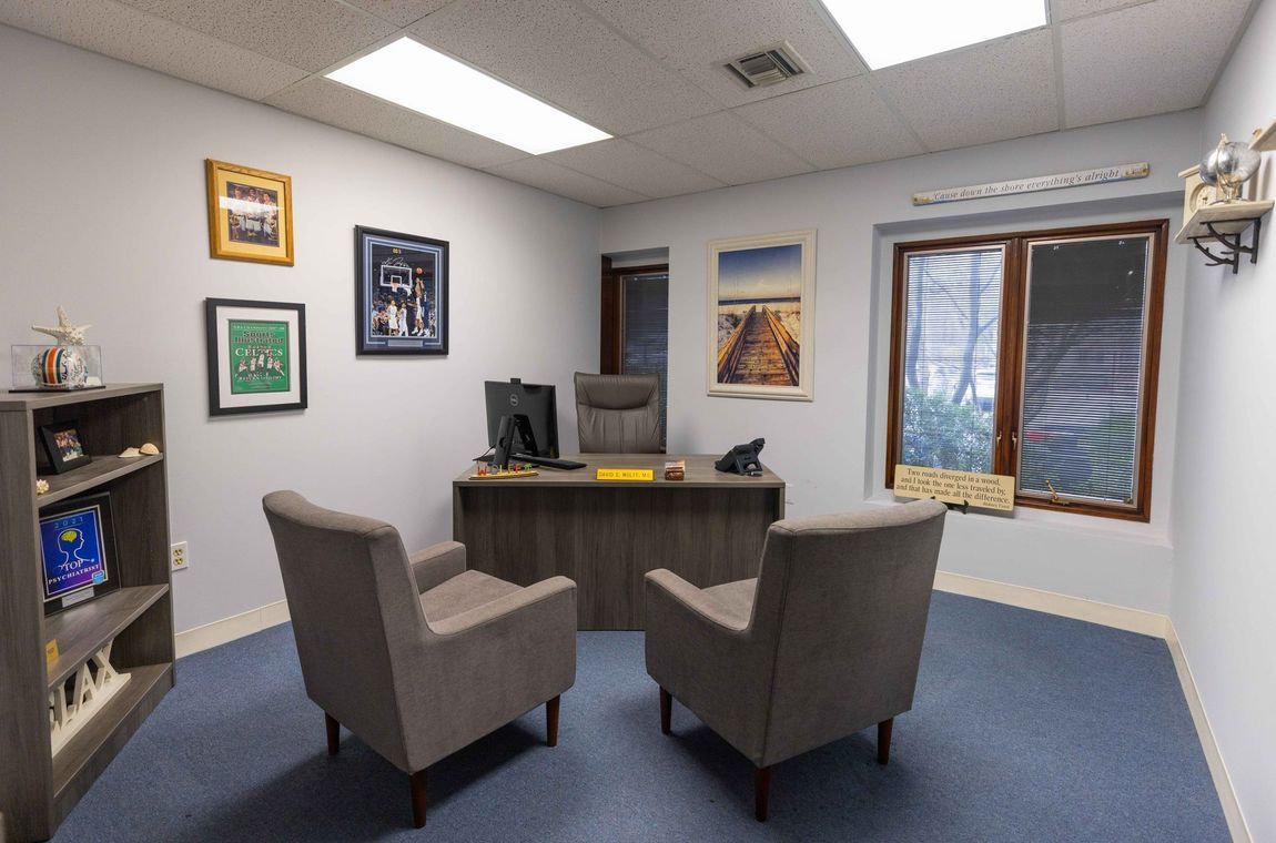 A room with two chairs and a desk with a computer on it.