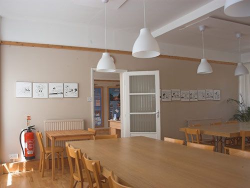 A dining room with tables and chairs and a fire extinguisher
