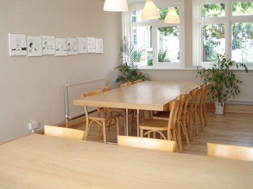A dining room with a long table and chairs