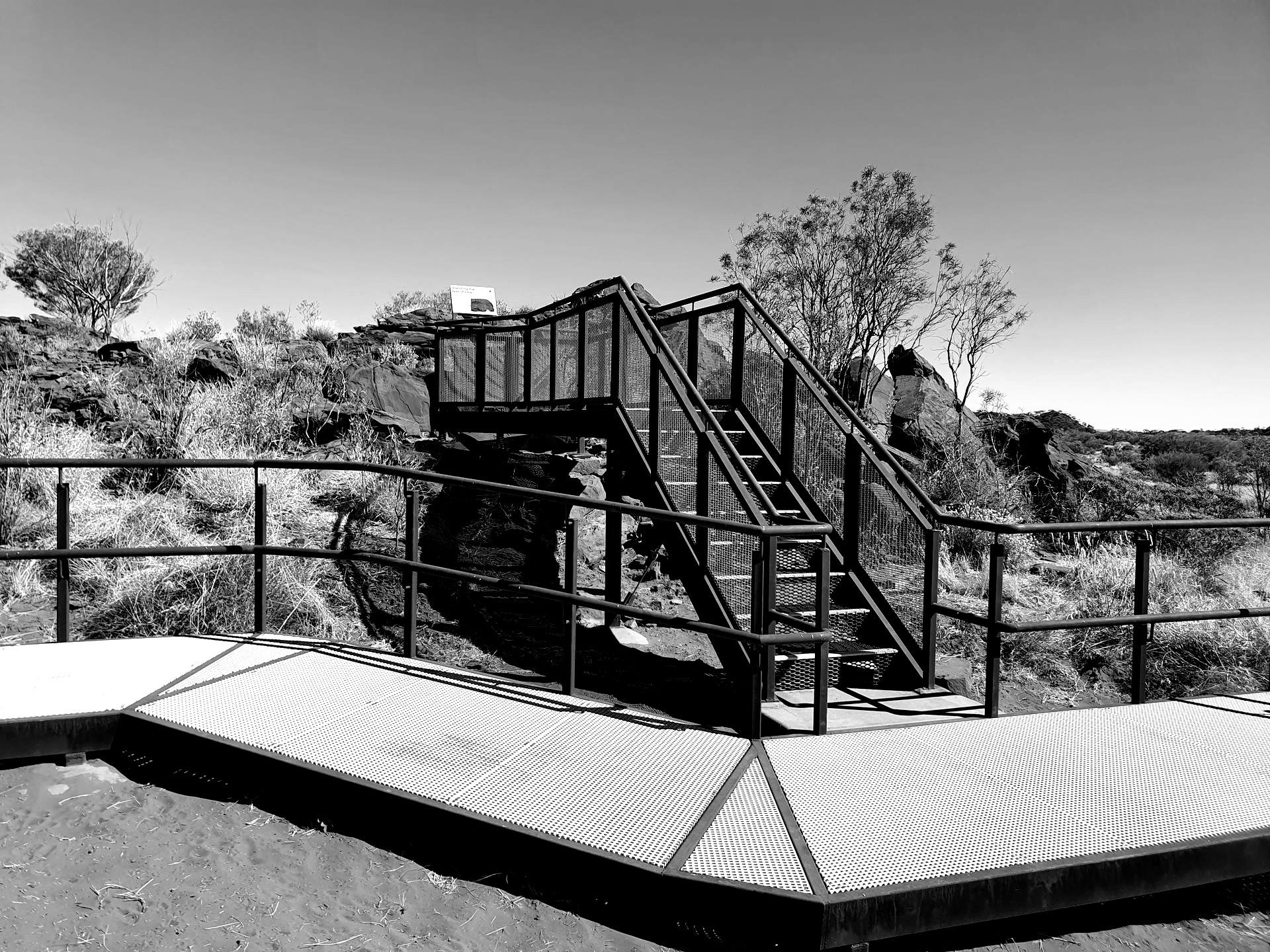 A black and white photo of a staircase with a railing
