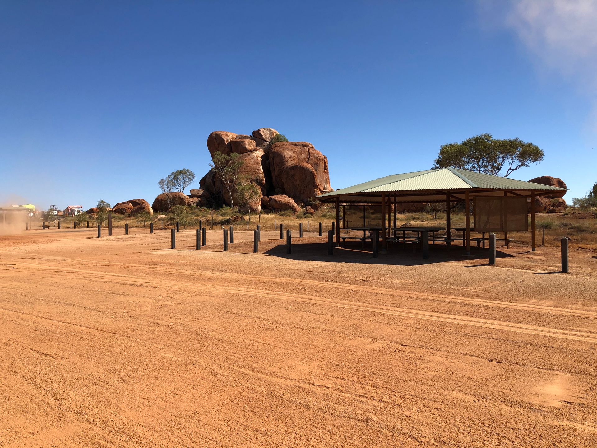 A picnic area in the desert with a large rock in the background